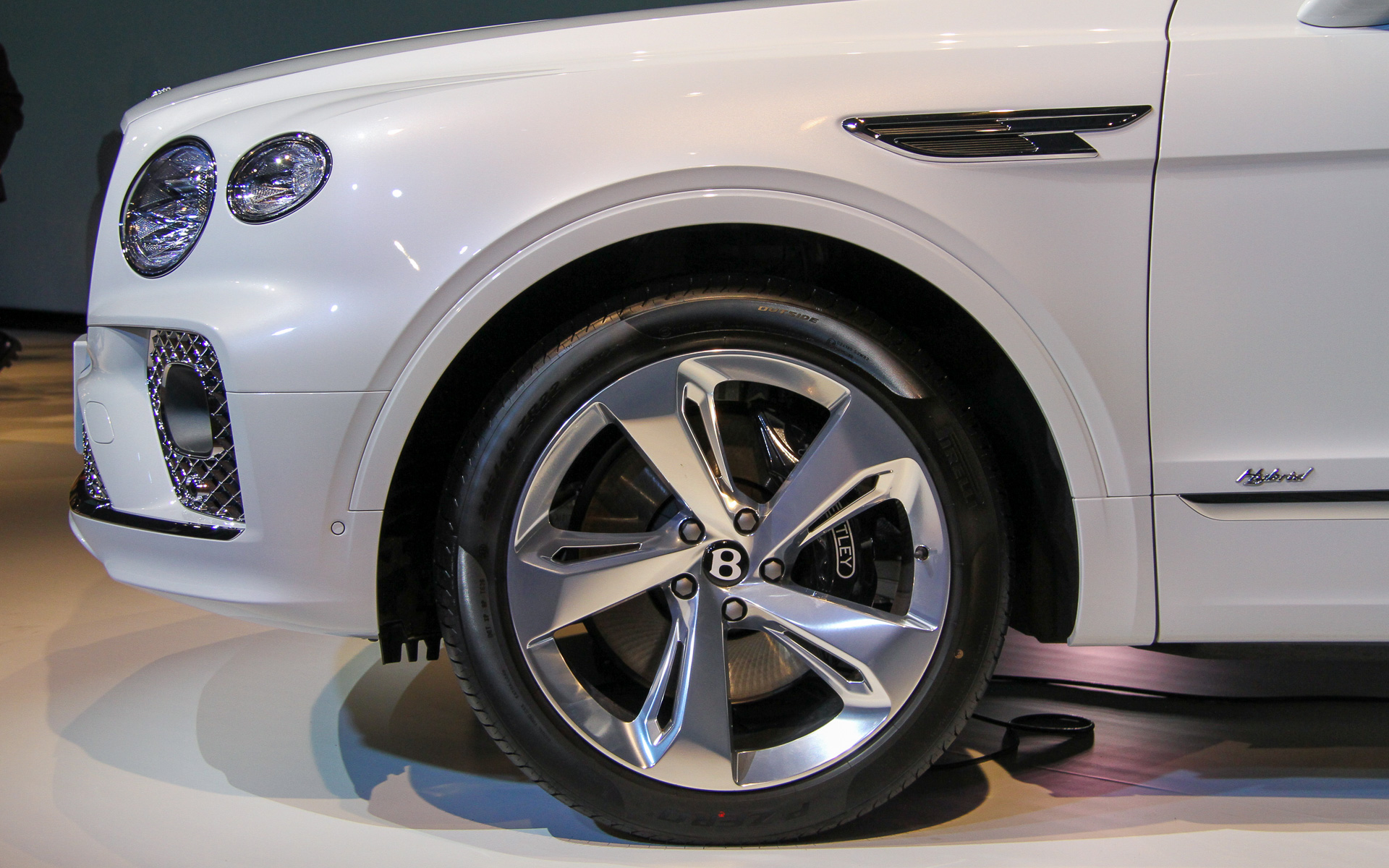 ベンテイガ ハイブリッドのボディサイズは5125×1995×1740mm（全長×全幅×全高）、ホイールベースは2995mm。車両重量はV8モデルから220kg増となる2690kg。撮影車はオプションの22インチホイール（タイヤサイズは285/40ZR22）を装着（標準は21インチホイールでタイヤサイズは285/45ZR21）。車両左側に充電リッド、右側にフューエルリッドが用意される