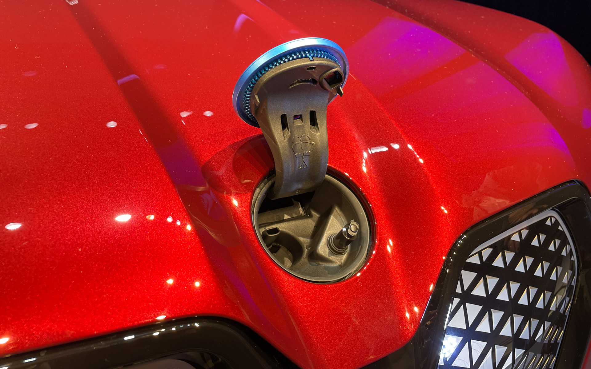 「iX」のウィンドウォッシャー液の補充口となる開閉式のBMWのエンブレム