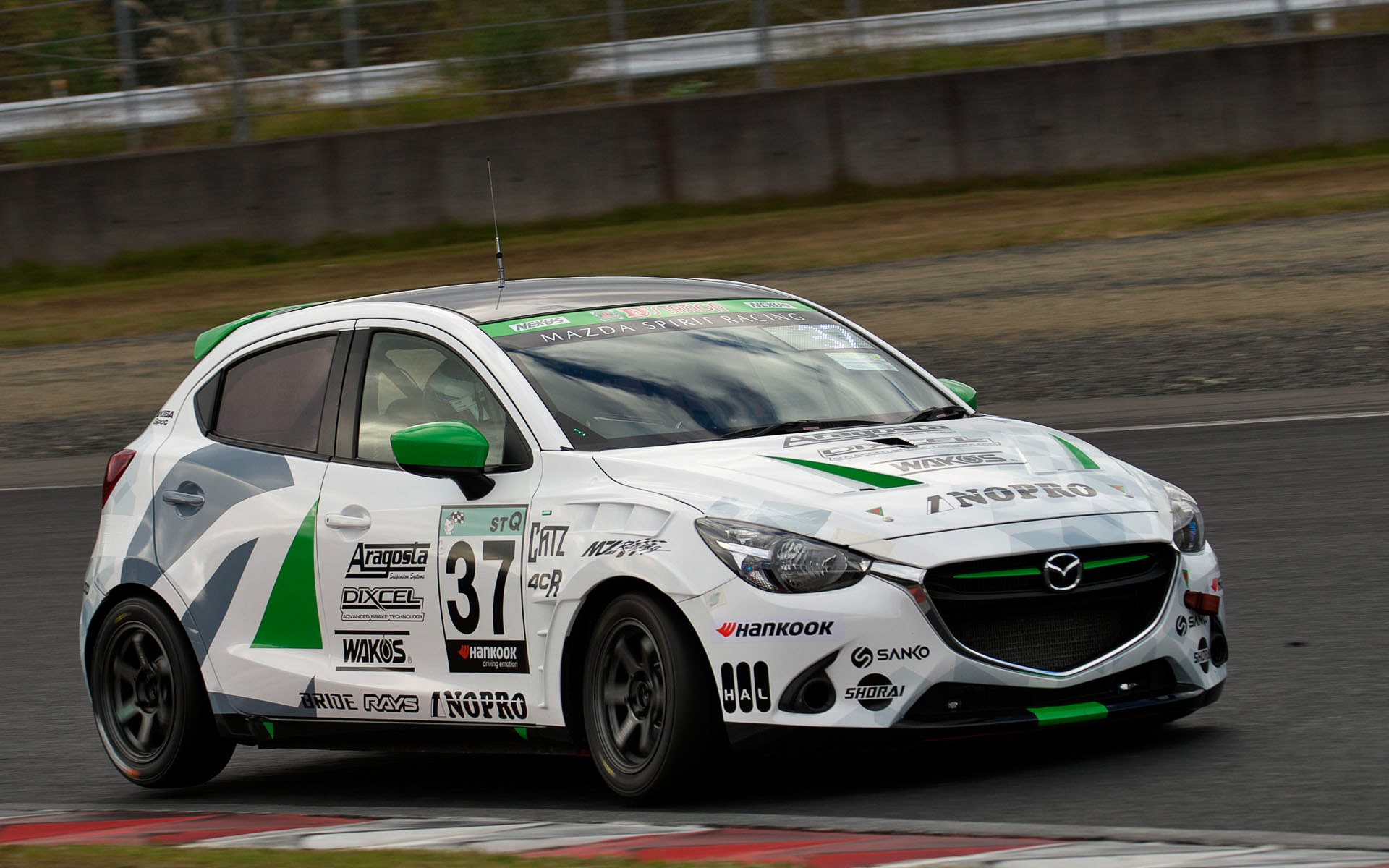 精力的に走行するMAZDA2。フロントグリルにはグリーンのラインが