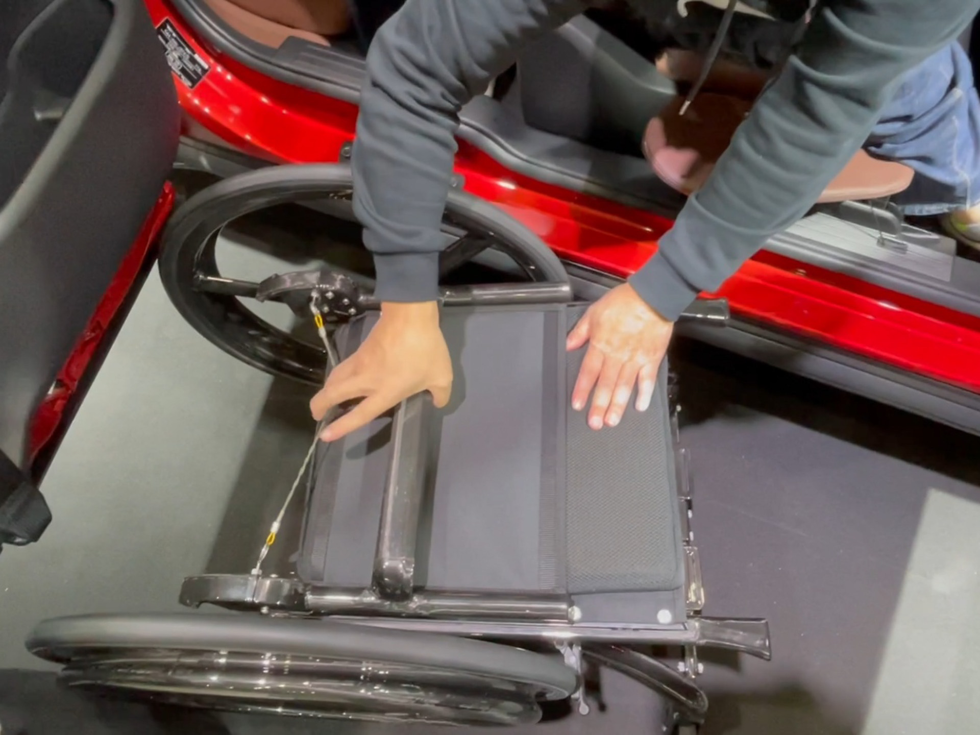 背もたれ裏のワイヤを引いて背もたれを折りたたんだ後、バーをつかんでそのまま持ち上げることでシートと背もたれが外れる