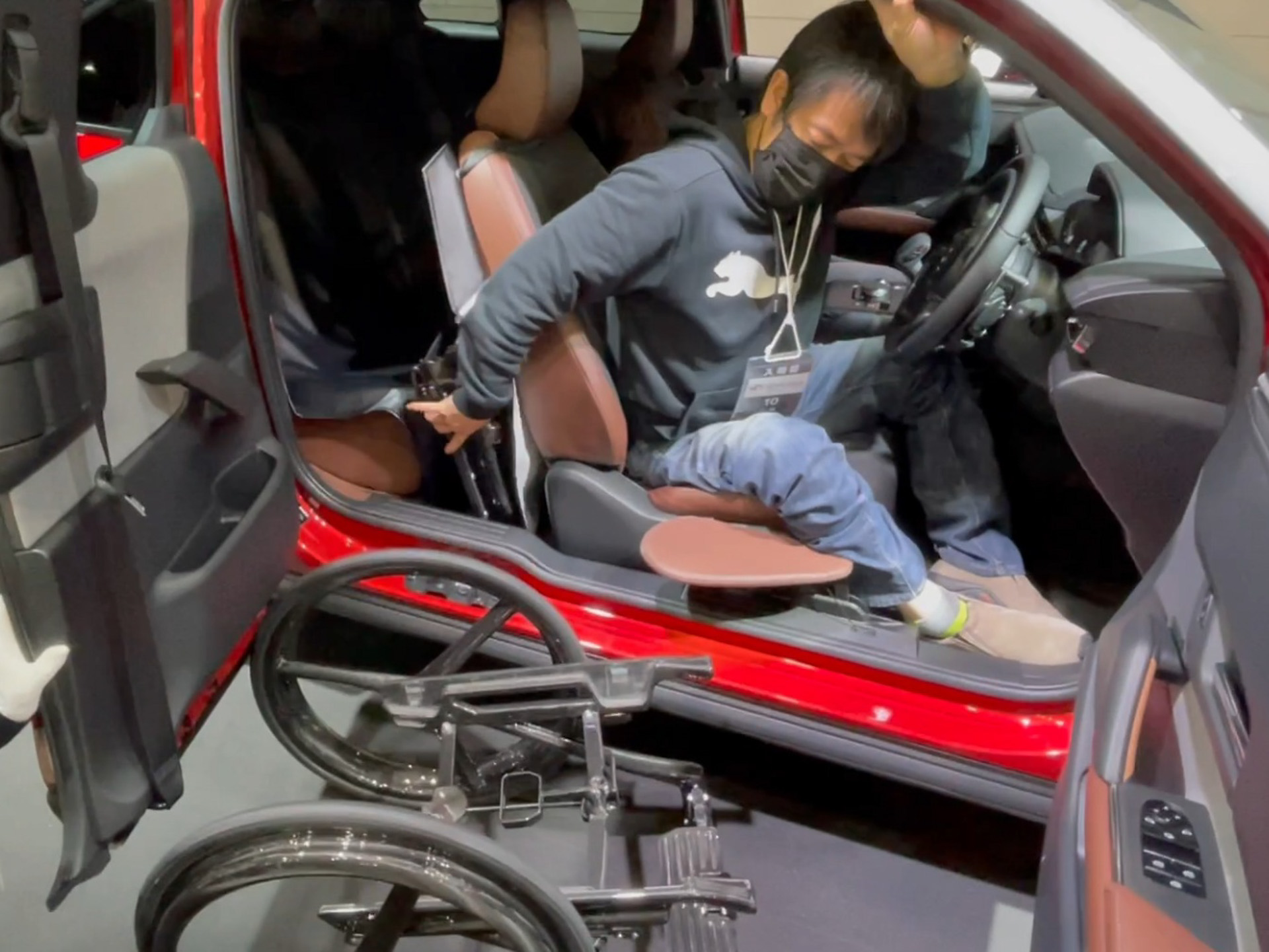 車いすから取り外した、折りたたんだシートと背もたれは後部座席の足元に収納する