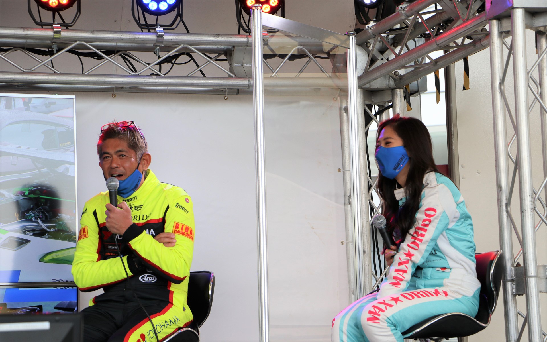 ステージイベント「愛車自慢駐車場 出張」でユーザーカーを見てコメントしている土屋圭市選手、谷口信輝選手、織戸選手親子