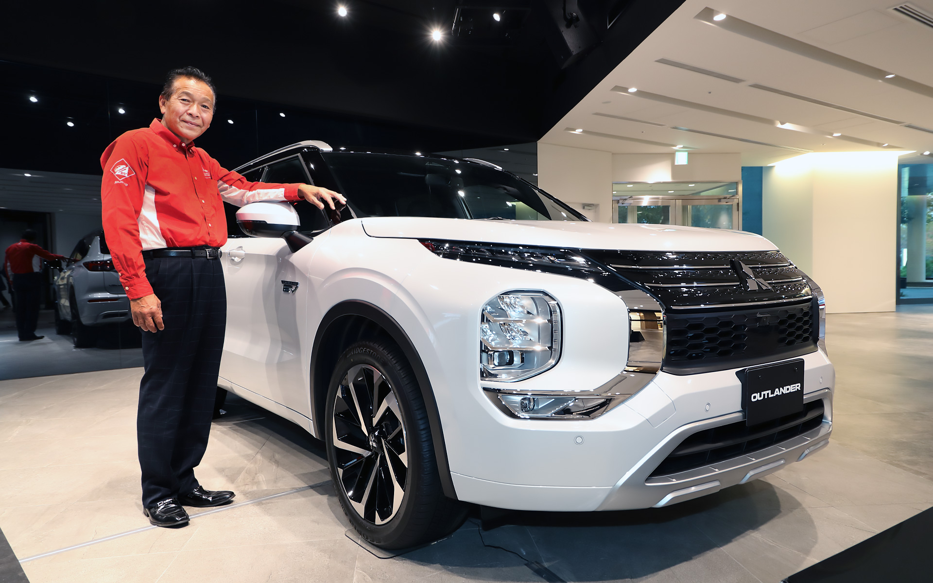 先行展示中の新型アウトランダーPHEVと。その仕上がりに並々ならぬ自信を見せる増岡氏