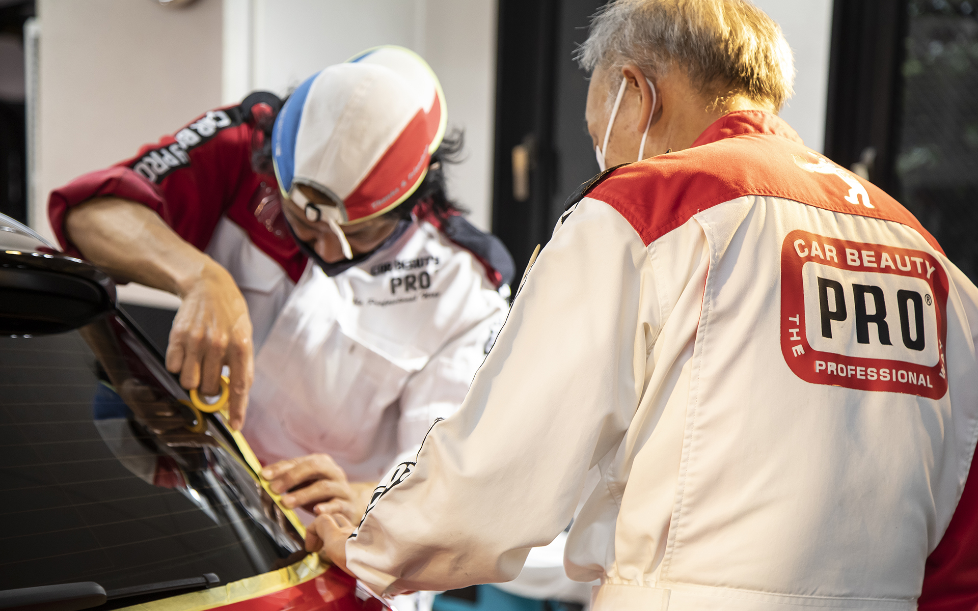 取材にうかがった日もスクール開校日。講習生の方が磨きを行なう前のマスキング術を学んでいる最中だった。白いマスクの方がスクールの校長である高井雅弘氏