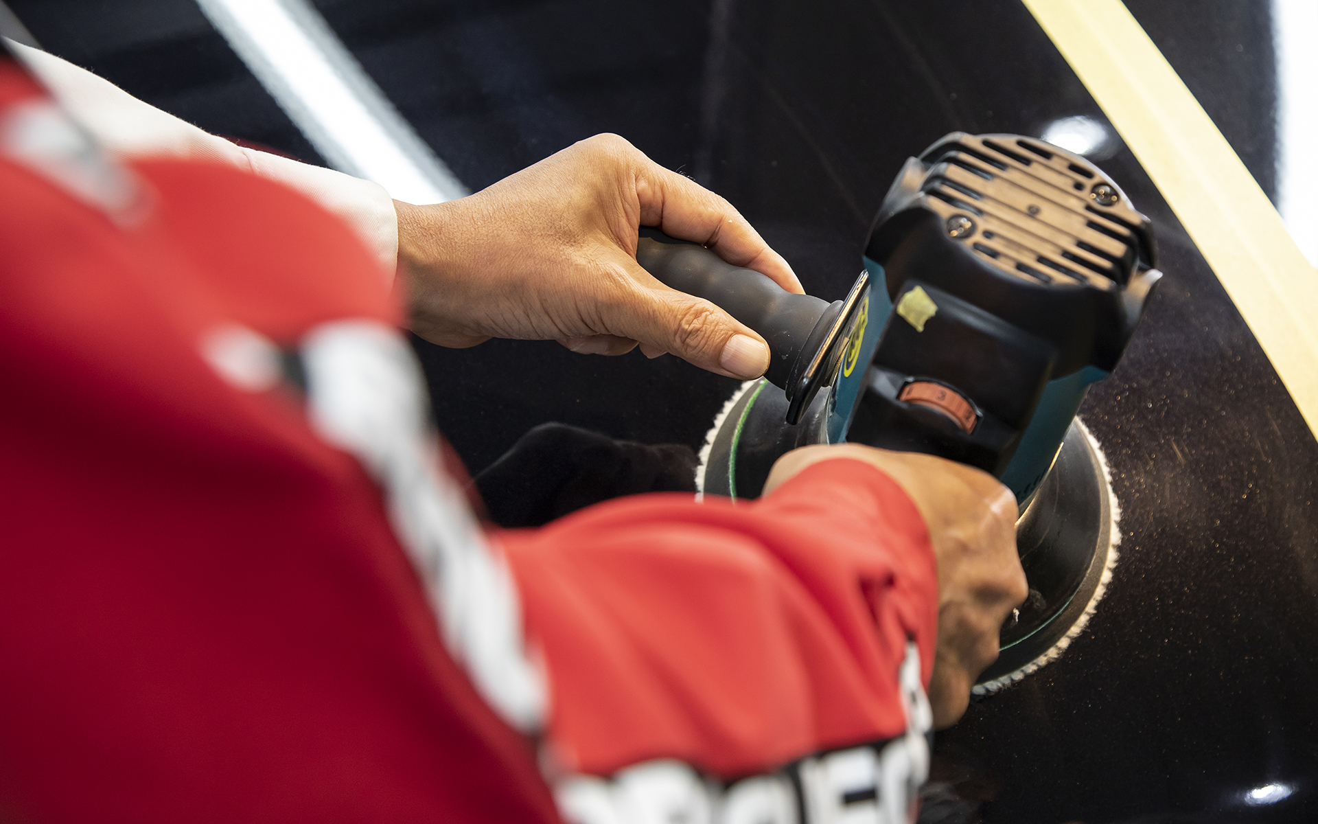 ポリッシャーの持ち方。右手でメインのグリップを支えて、左手は軽く添えて動かしたい方向へ身体ごと軽く押すように操作