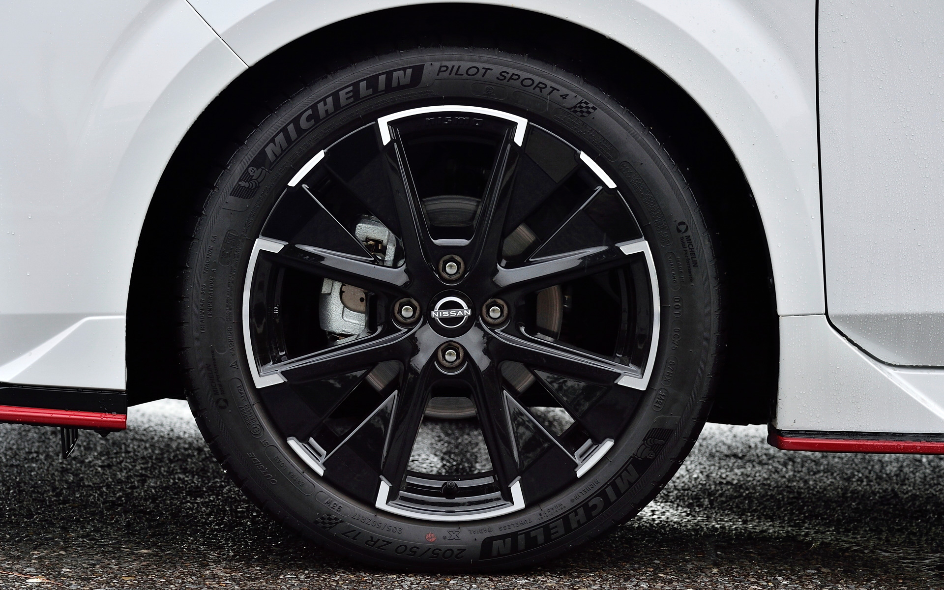 エクステリアではNISMO専用に最適化した空力デザインを採用するとともに、NISMOのアイコンであるレッドアクセントの「レイヤード・ダブルウイング」によって低重心でロー&ワイドなフォルムを実現。フロントバンパーにはバンパーサイドにフロントサイドエアスプリッターとインレットダクトを設定し、空気流の剥離を抑え、スプリッター内に取り込む空気流、バンパー側面の空気流もスムーズに流れるよう整えた。リアバンパーにはコーナーにリアサイドエアスプリッターを設定し、バンパー後端のコーナー部を横および後方に張り出し、バンパー側面の空気流の剥離ポイントを制御する。高い空力性能を確保しつつワイドリム化された17インチアルミホイールにはミシュラン「パイロットスポーツ4」(205/50ZR17)をセット