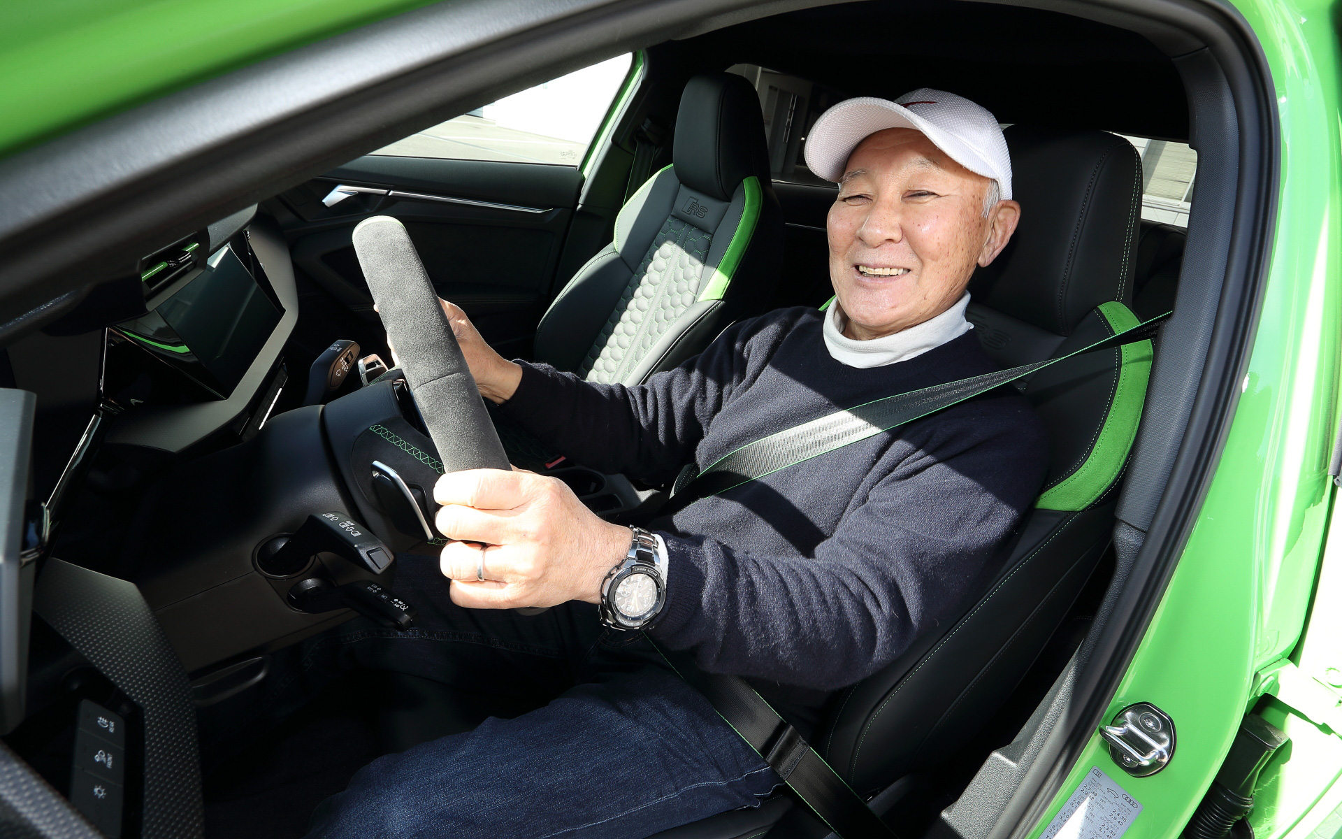 富士スピードウェイで行なわれたAudi Sport試乗会では、最新の「RS 3」に試乗できた。試乗車は「RS 3 セダン」（818万円）で、ボディサイズは4540×1850×1410mm（全長×全幅×全高）、ホイールベースは2630mm。フロントまわりではワイドなRSバンパーを装着し、シングルフレームにはハイグロスブラックのハニカムグリルを組み合わせ、フラットなウェッジシェイプLEDヘッドライトとLEDリアコンビネーションダイナミックターンインディケーターを標準装備。フロントホイールアーチ後方には新たなデザインエレメントとしてエアアウトレットを新設。フロントトレッドは先代モデルと比較して約30mm拡大し、スポーツバックではリアトレッドも約10mmワイドになった