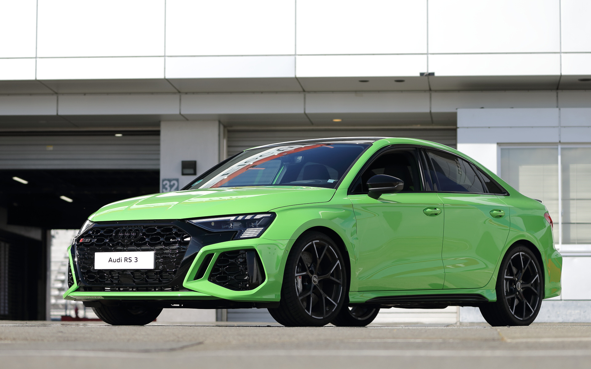 富士スピードウェイで行なわれたAudi Sport試乗会では、最新の「RS 3」に試乗できた。試乗車は「RS 3 セダン」(818万円)で、ボディサイズは4540×1850×1410mm(全長×全幅×全高)、ホイールベースは2630mm。フロントまわりではワイドなRSバンパーを装着し、シングルフレームにはハイグロスブラックのハニカムグリルを組み合わせ、フラットなウェッジシェイプLEDヘッドライトとLEDリアコンビネーションダイナミックターンインディケーターを標準装備。フロントホイールアーチ後方には新たなデザインエレメントとしてエアアウトレットを新設。フロントトレッドは先代モデルと比較して約30mm拡大し、スポーツバックではリアトレッドも約10mmワイドになった