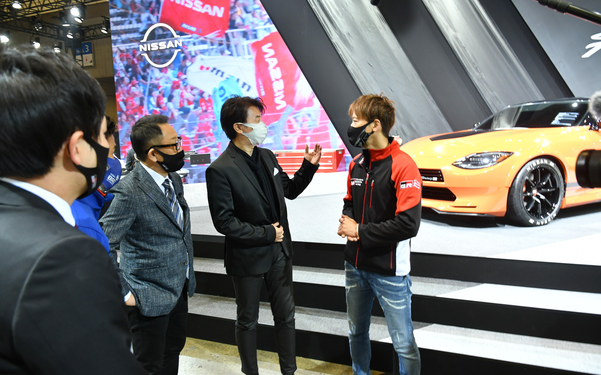 新型Zが展示されている日産ブースへアポナシで突撃する御一行。たまたまいたデザイナーの入江慎一郎氏（中央）から説明を受ける