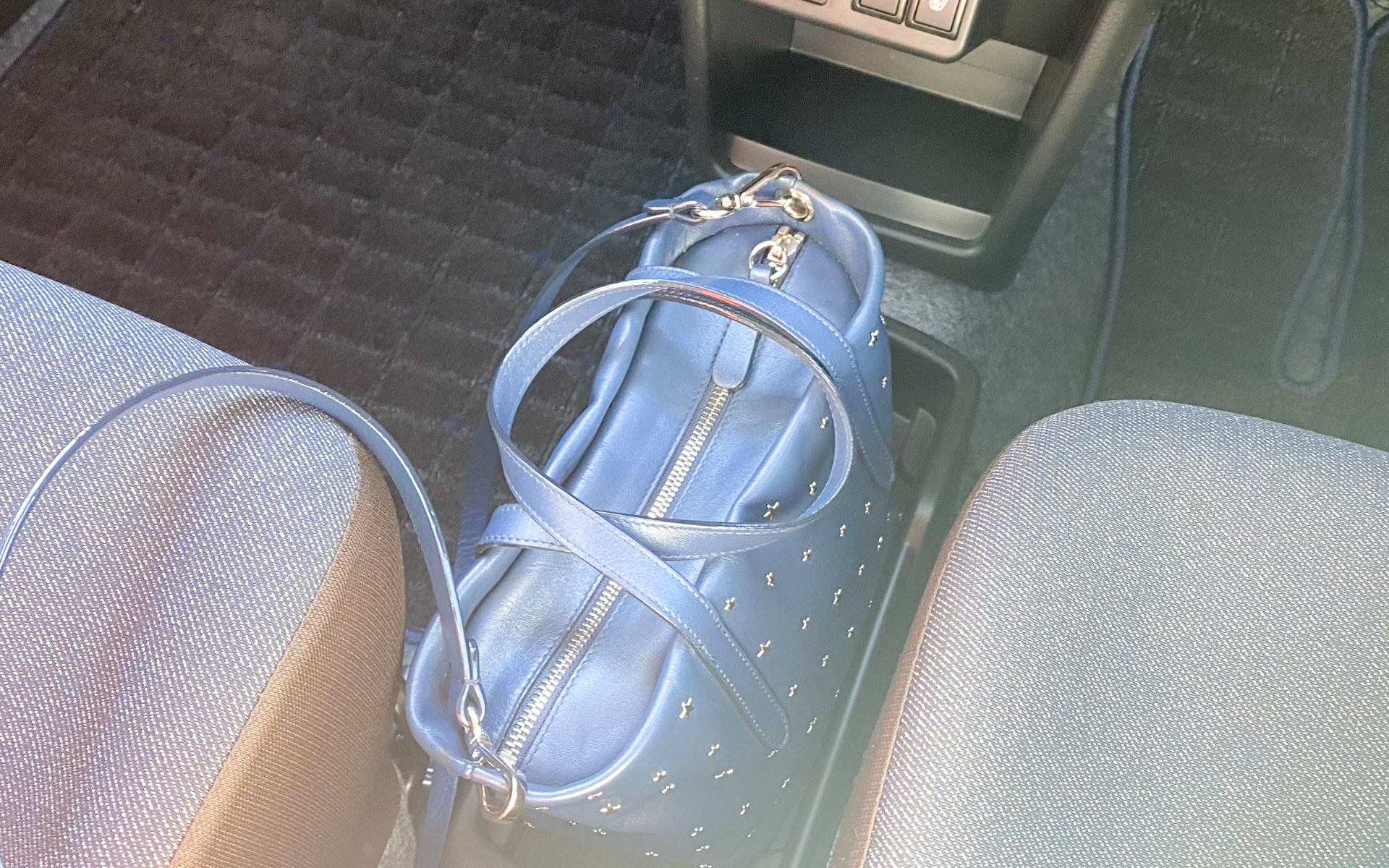 新型アルトで気に入ったポイントは、このハンドバッグも置けちゃうフロアトレイ。運転席と助手席の間にある隙間をうまく使って、女性がいつも困るバッグ置き場を作ってくれました。これはナイス！