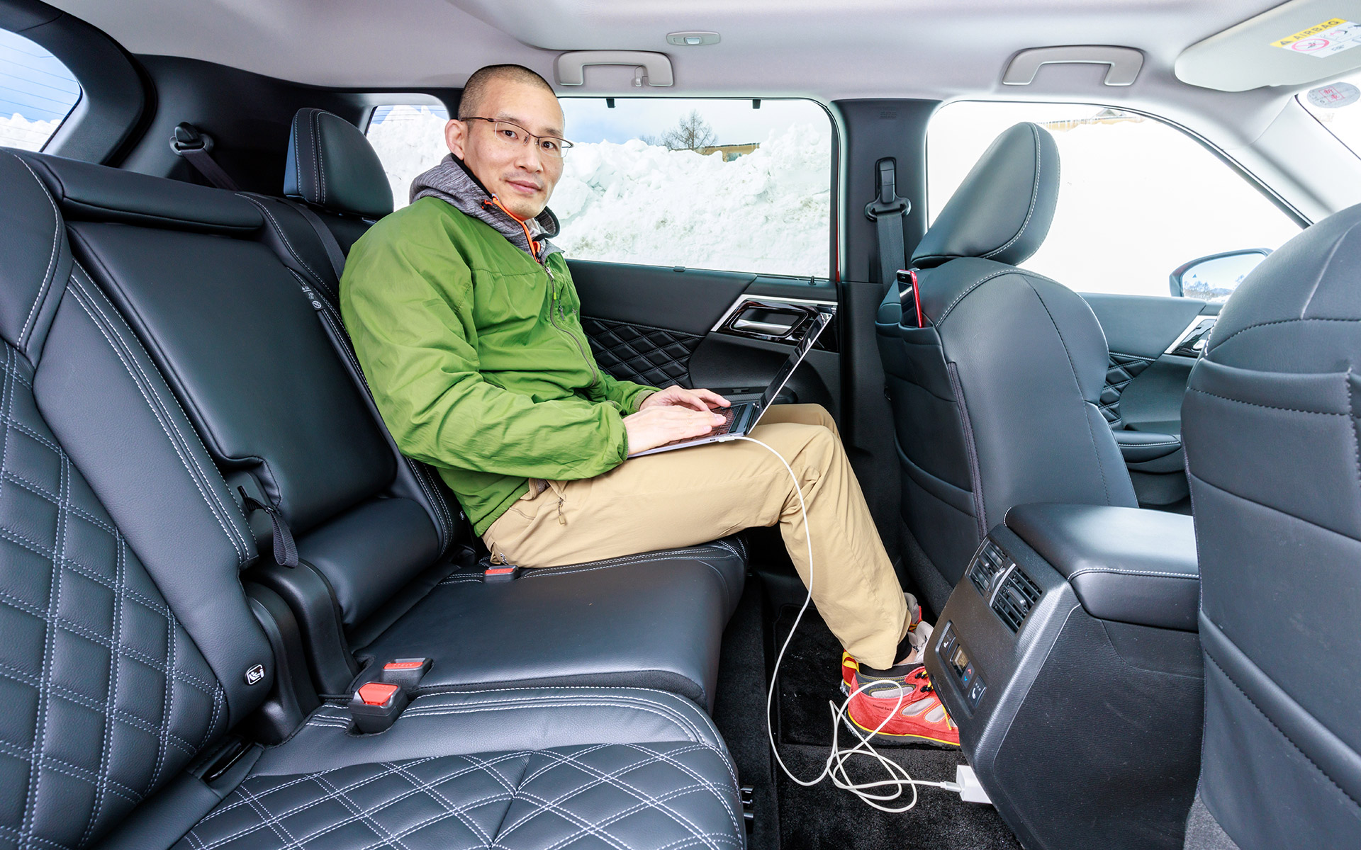 2列目シートでノートPCを電源に接続しながら仕事中。1500WのAC電源を利用できるので、ノートPCをフルパワーで利用できる。そのためストレスなく仕事が可能だし、電源を探し回る必要もない