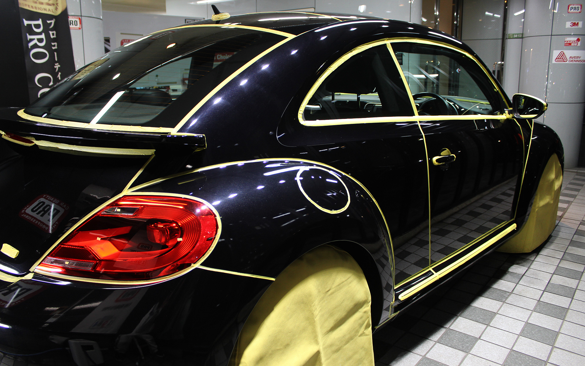 マスキング作業。パネルの継ぎ目、ライト、突起物などの境目にすべて施す。安全に研磨作業を行なうための重要な工程となる