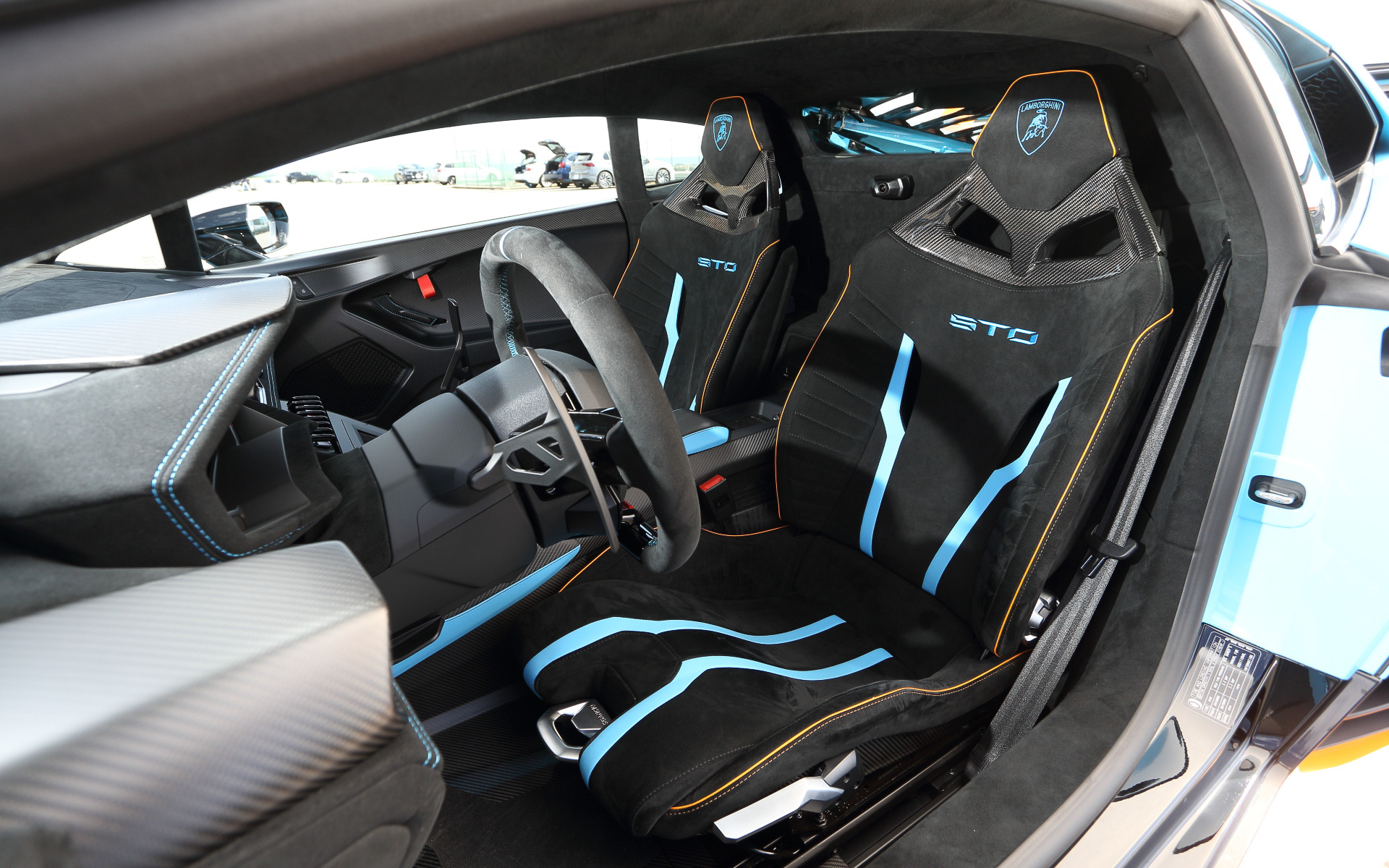 カーボンファイバー製のシートには、ボディと同色で「STO」と「ランボルギーニ」のロゴが入る。また、ボディの挿し色と同じオレンジ色でステッチが施されている