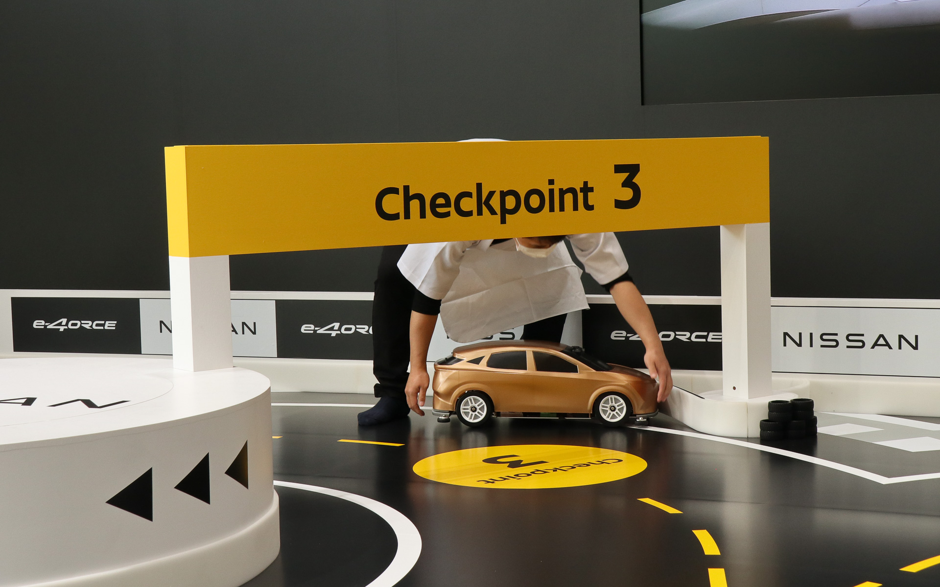 e-4ORCE ラジコンカーは後退できないので、壁に当たって走行不能になってしまった場合はラーメン店の店員に扮したサポートスタッフがコース復帰させる