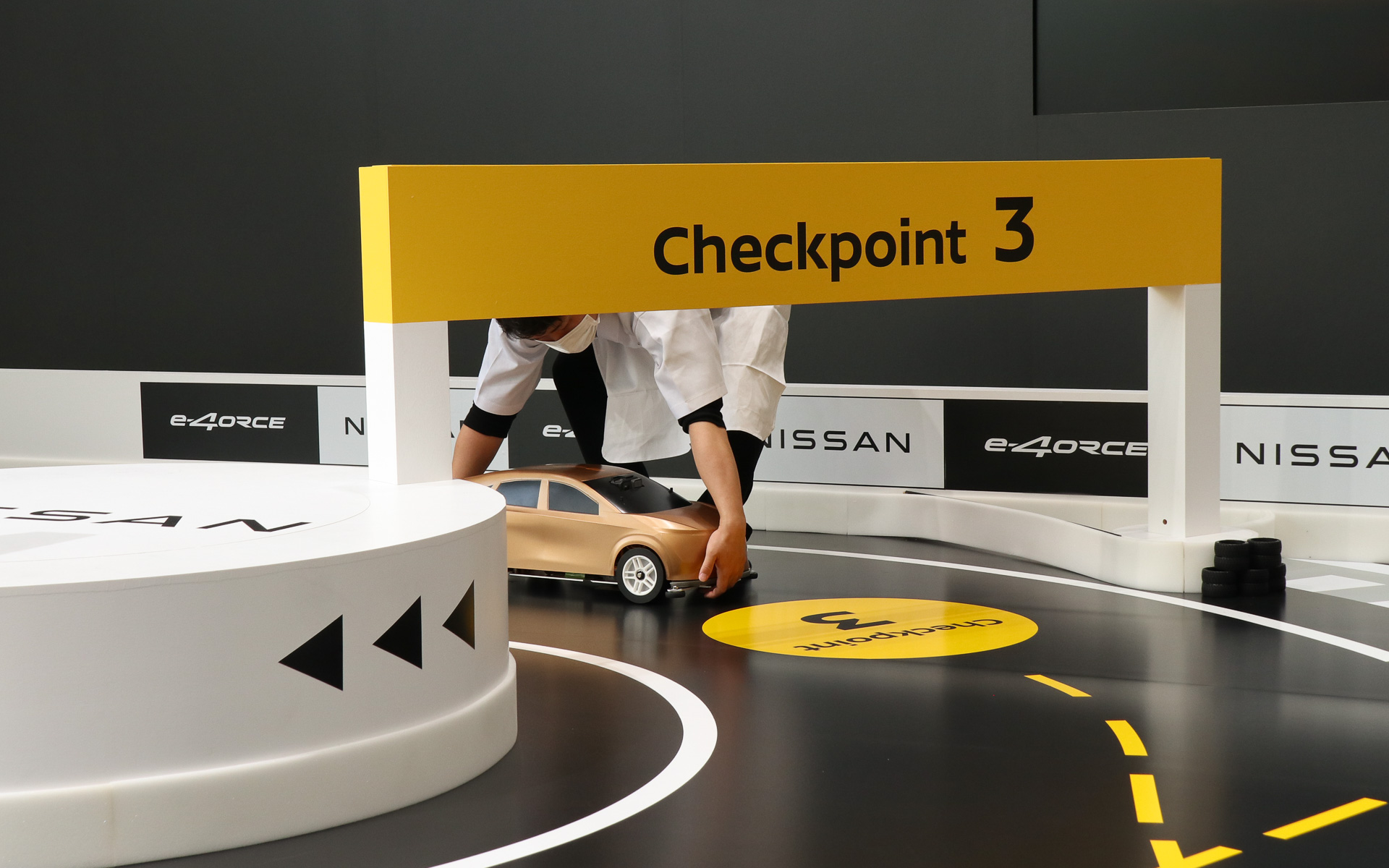 e-4ORCE ラジコンカーは後退できないので、壁に当たって走行不能になってしまった場合はラーメン店の店員に扮したサポートスタッフがコース復帰させる