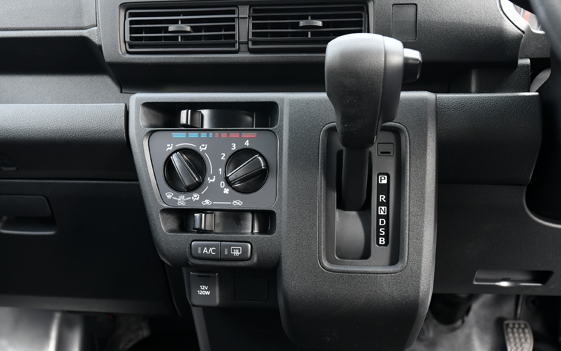 ハイゼット カーゴの内装。小物を多く収納できるよう、オーバーヘッドシェルフ（一部グレード）や助手席トレイなどの機能的な収納を充実