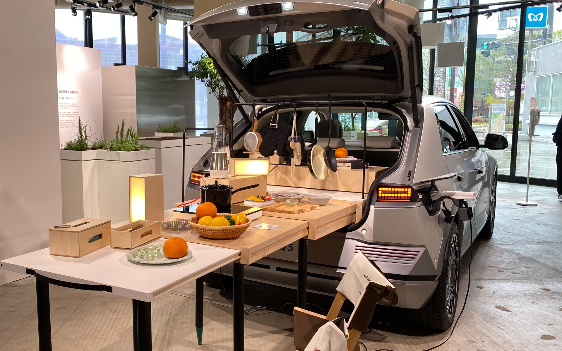 エントランスに展示されているIONIQ 5は、フロントから見ていると普通に置いてあるだけかと思いきや、リアにまわるとこんな光景にびっくり。アウトドアで、出来立てホヤホヤのおいしい料理をいただいている様子が目に浮かんで来るようです。こんなことができるのも、EVのいいところですよね