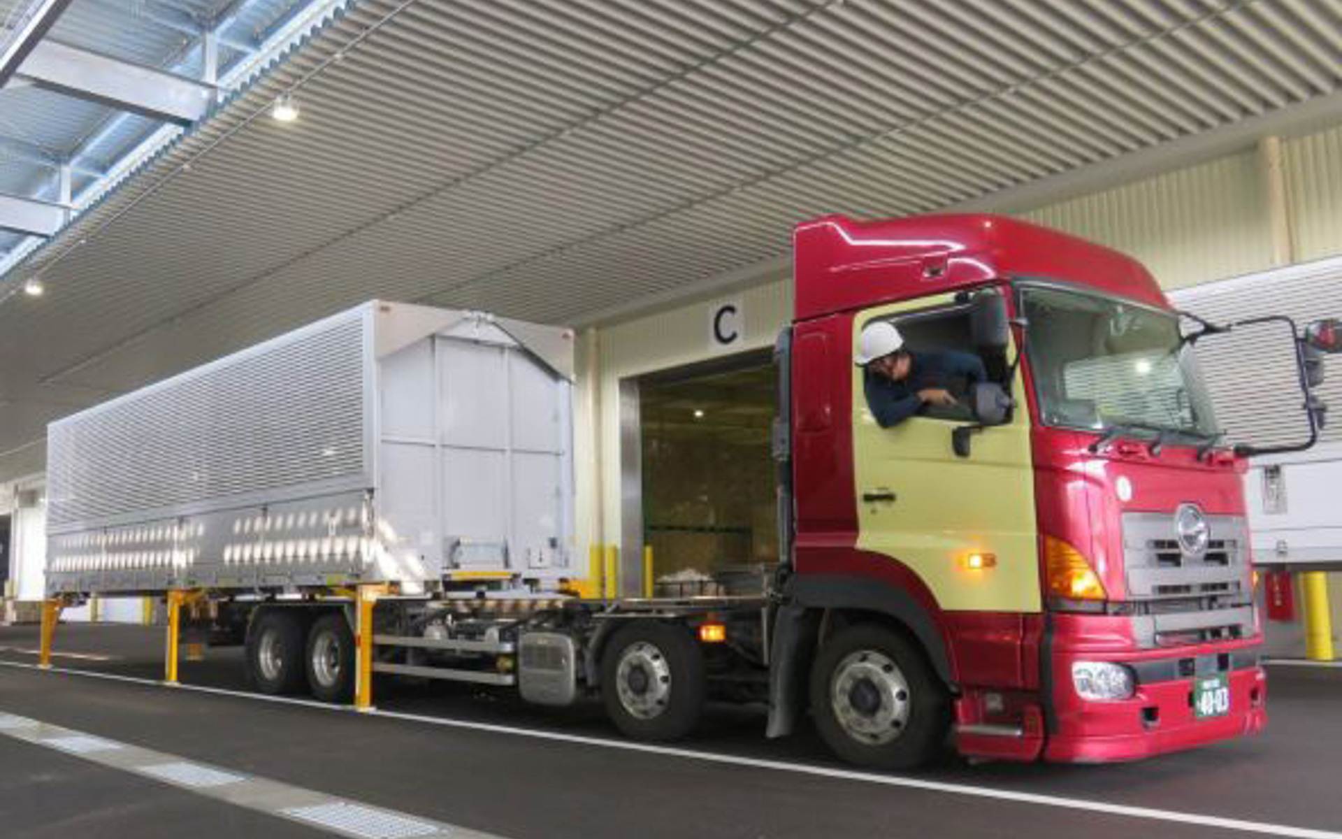 写真はトラック到着後にコンテナを脱着しているところ