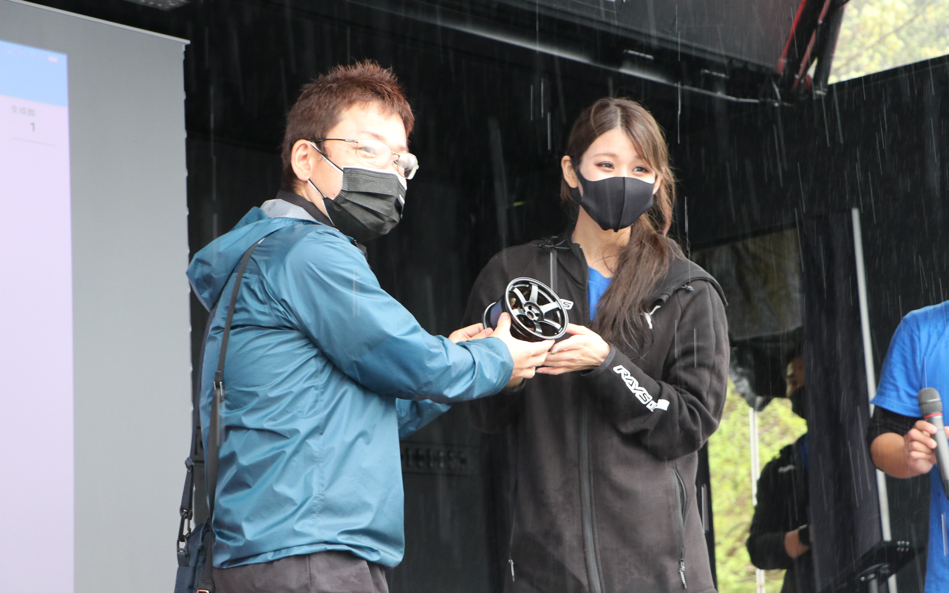 レースクイーンの沢すみれさんから直接商品を手渡しされ、会場からは「羨ましい！」の声が