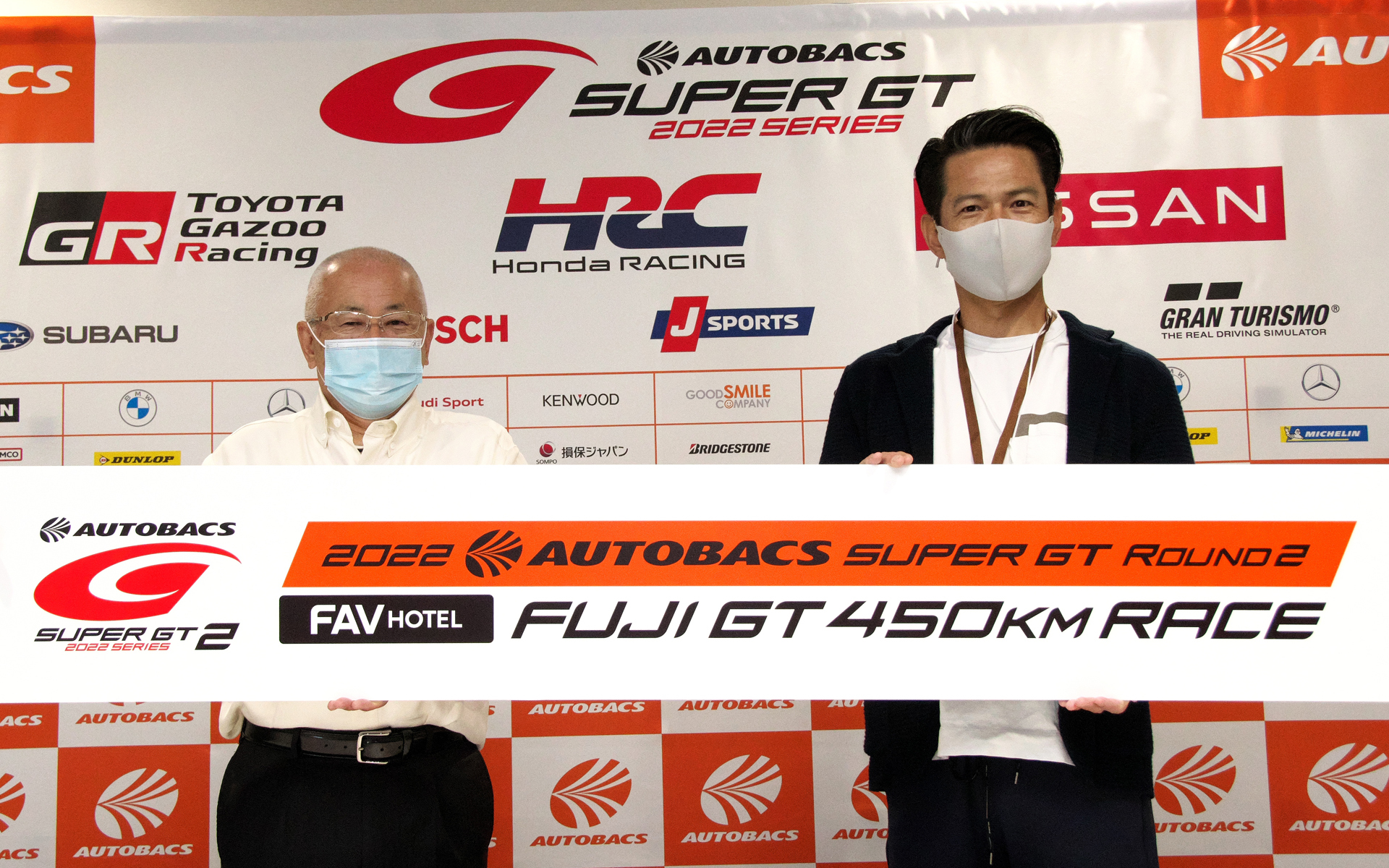 ラウンドスポンサーFAV HOTELの名称が入ったバナーを掲げる株式会社GTアソシエイション 代表取締役 坂東正明氏（左）と霞ヶ関キャピタル株式会社 代表取締役社長 河本幸士郎氏（右）