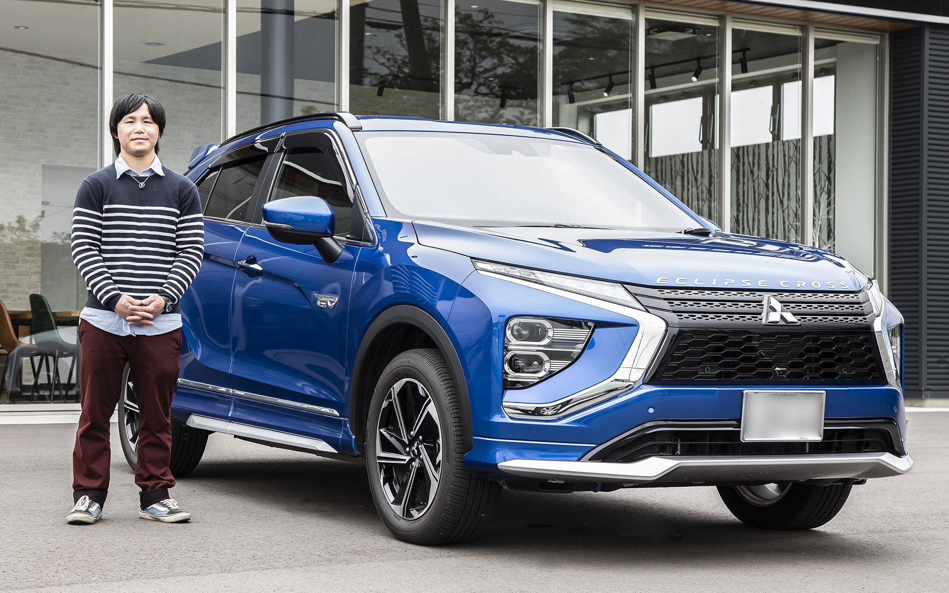 ライトニングブルーマイカのエクリプス クロス PHEVのオーナー菅谷さん。スタイルが気に入ったことが購入のきっかけだったが、いまはPHEVの便利さも気に入っているという