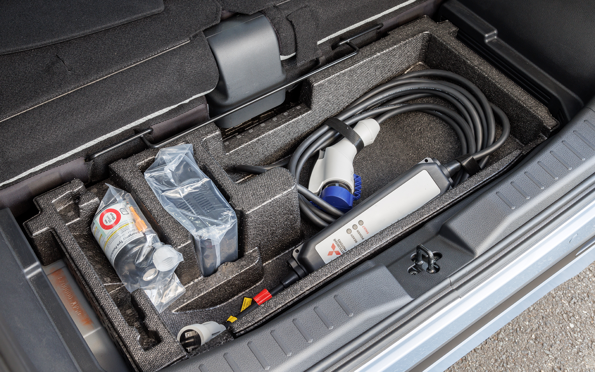 ラゲッジボード下には収納スペースを用意。パンク修理キットやAC200V用充電ケーブルが納められている