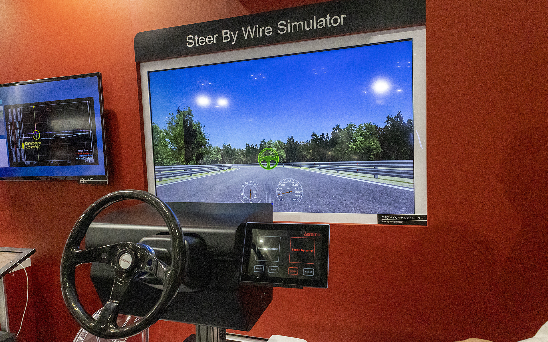 ステアバイワイヤのシミュレーター。ロッドでつながる従来のステアリングとの操作フィーリングの違いが体験できる。ステアバイワイヤではダイレクト感を出すほか、悪路でステアリングに伝わる衝撃を軽くしていた