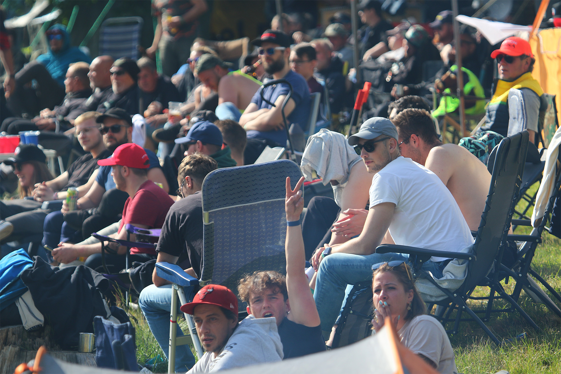 北コースに戻ってきたキャンプする人々。ビール片手にレース観戦をする人々