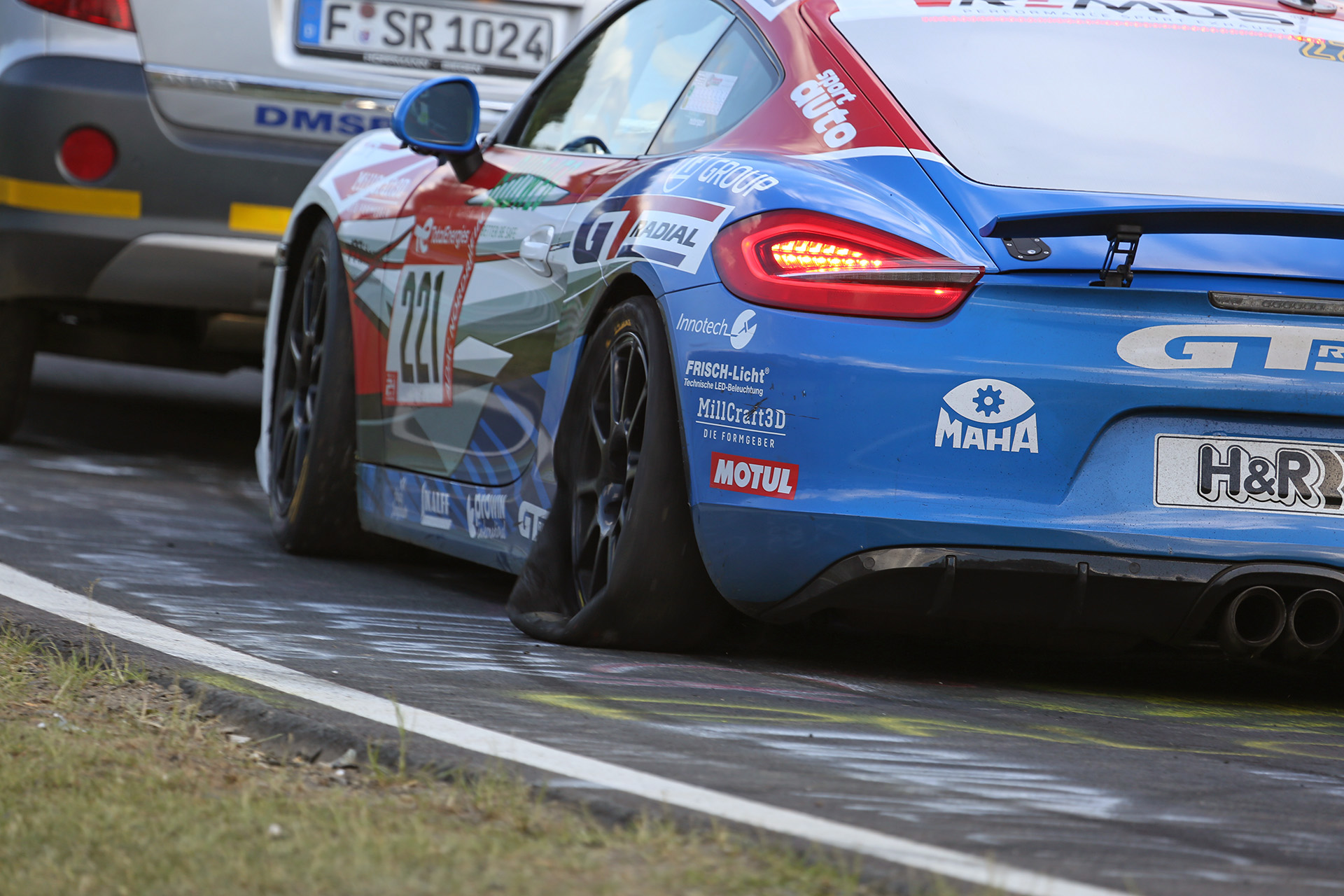 コース上を牽引されるパンクした車両