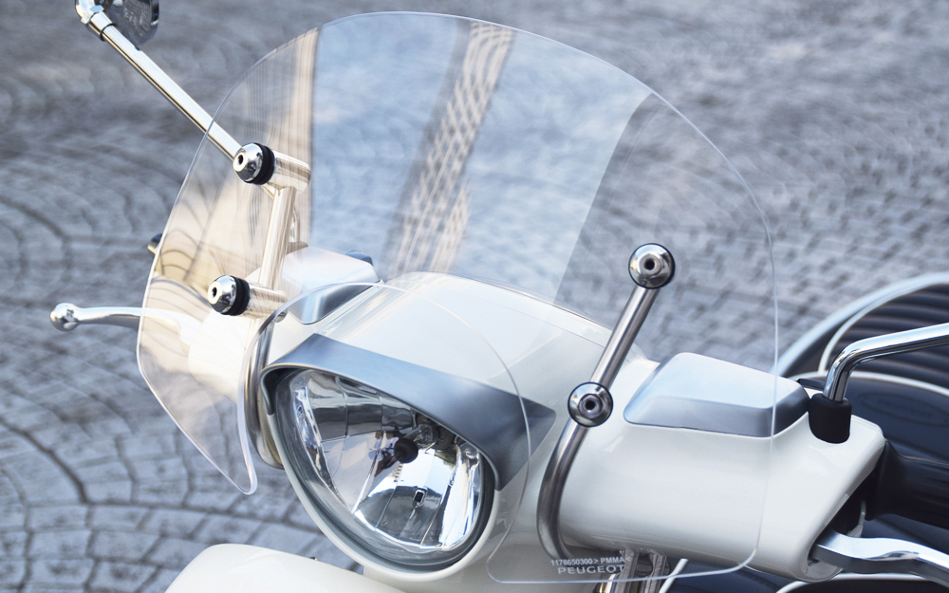 クロームメッキのステーにマウントされたショートスクリーンは、品質感を高めるとともにスタイリングを引き立ててくれる。また、ライダーの胸元にあたる風や雨を防ぎ、快適なライディングに寄与する。単品オプション価格3万2780円