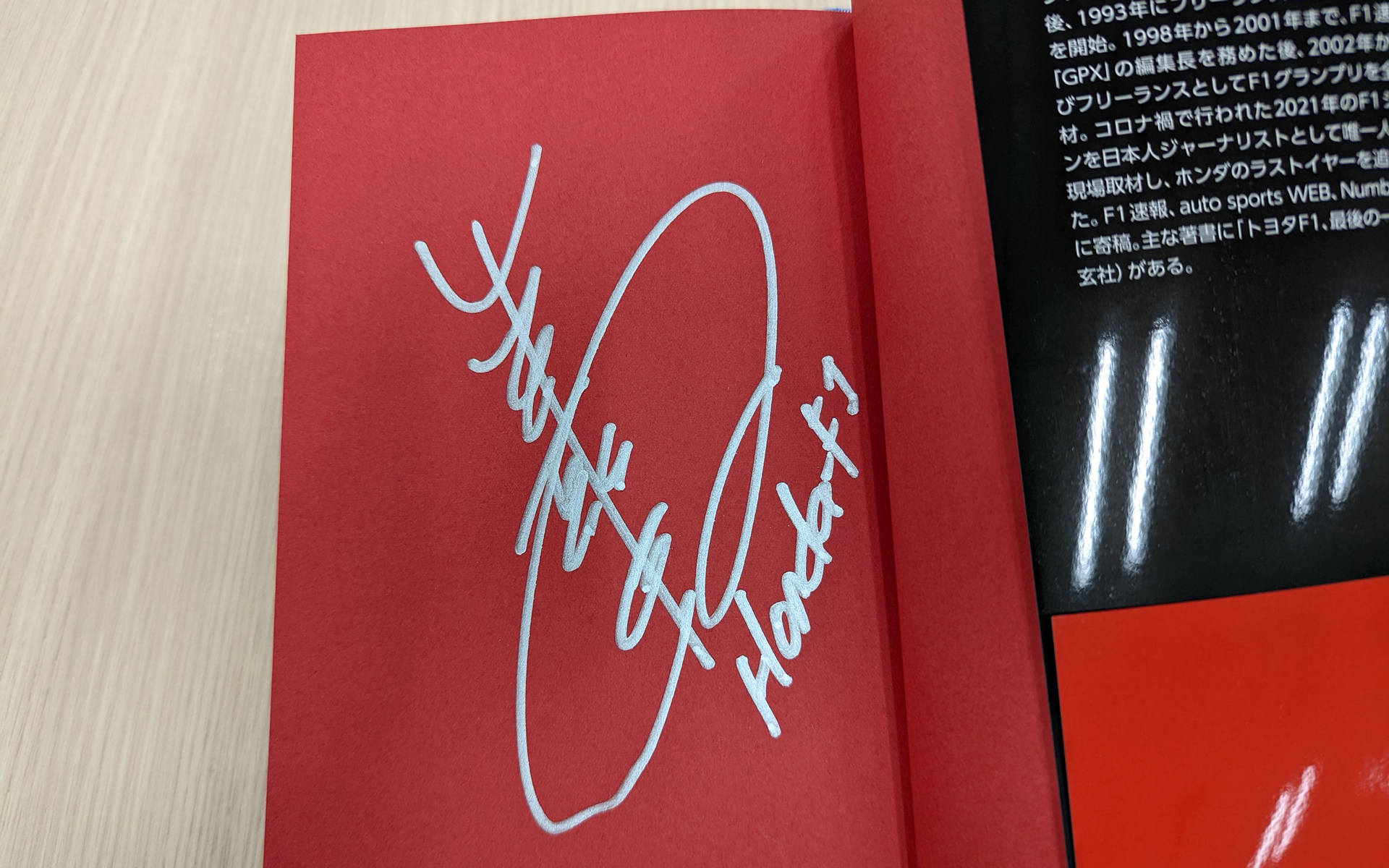モナコGPの現場で著者の尾張氏が山本氏にサインを依頼して書いてもらいました