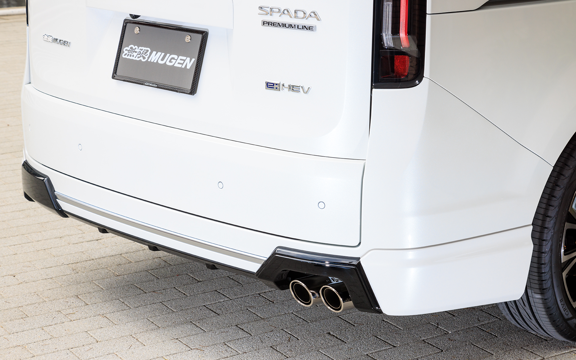 リアアンダースポイラー。ボディカラーとツヤありブラック塗装の2トーン仕上げ（写真の無限スポーツサイレンサー同時装着用は2022年10月発売予定、標準マフラー用は2022年8月発売予定、価格はいずれもカラード仕上げ8万2500円、未塗装7万1500円）