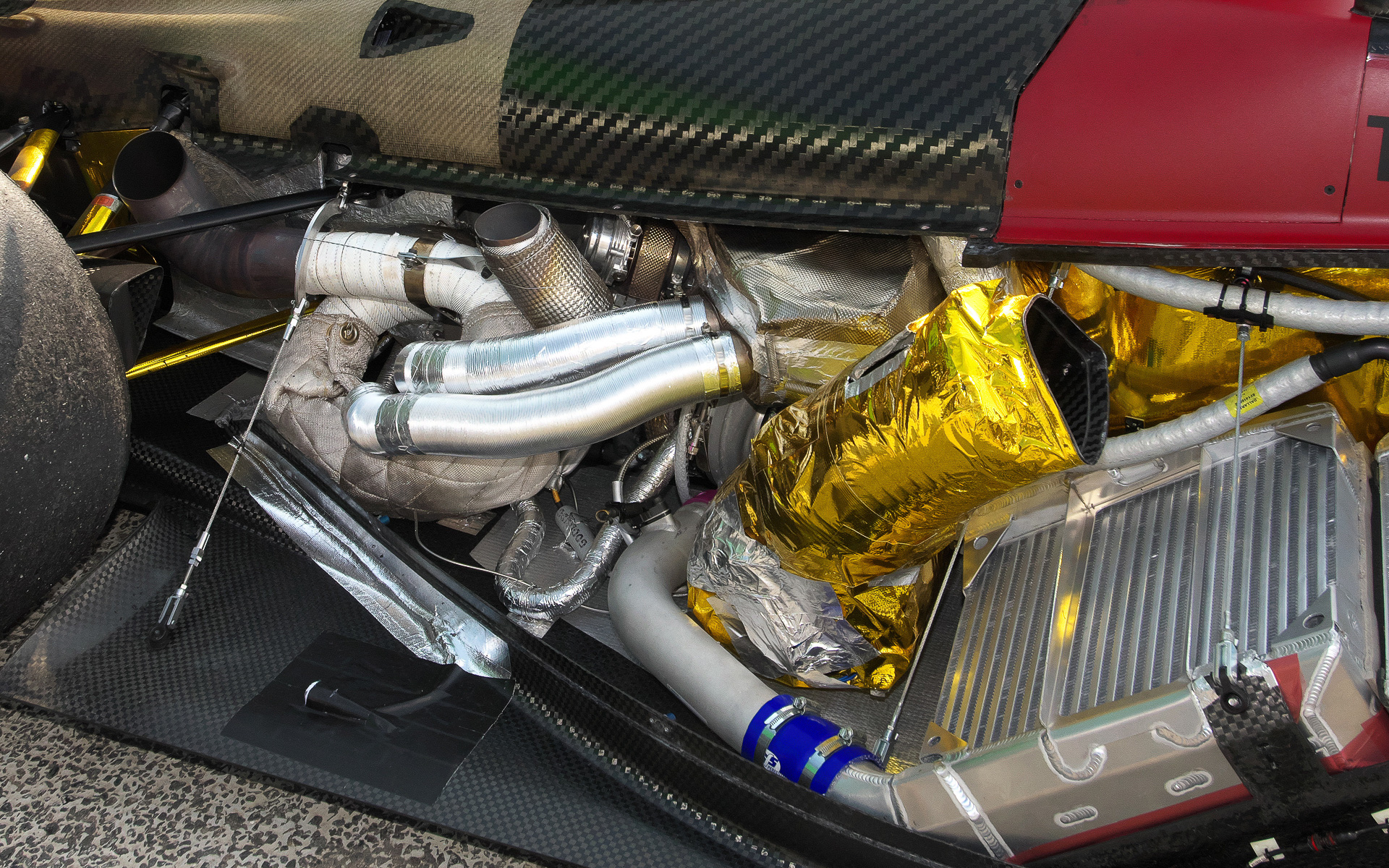 排気管部分をやや前から見たところ。手前の金色のダクトは吸気管