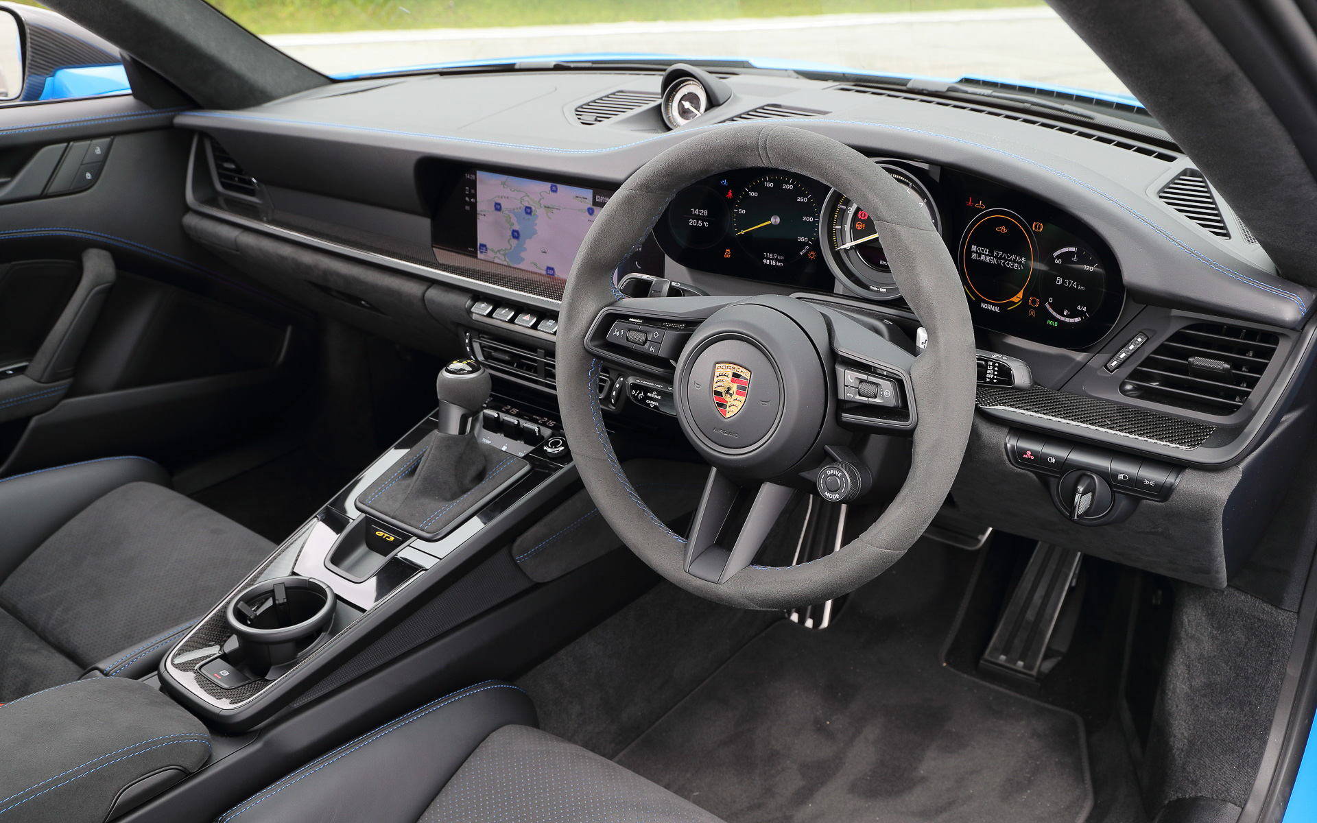 無償オプションの「クラブ スポーツ パッケージ」に含まれるスチール製ロールケージを装備して2名乗車仕様となる911 GT3のインテリア。メーター中央に最高回転数10000rpmのタコメーターをレイアウトし、タイヤ空気圧インジケーター、油圧、油温、燃料残量、水温といったサーキット走行に不可欠な情報を得ることが可能。フルバケットシートやシャークブルーカラーのシートベルトなどはオプション設定