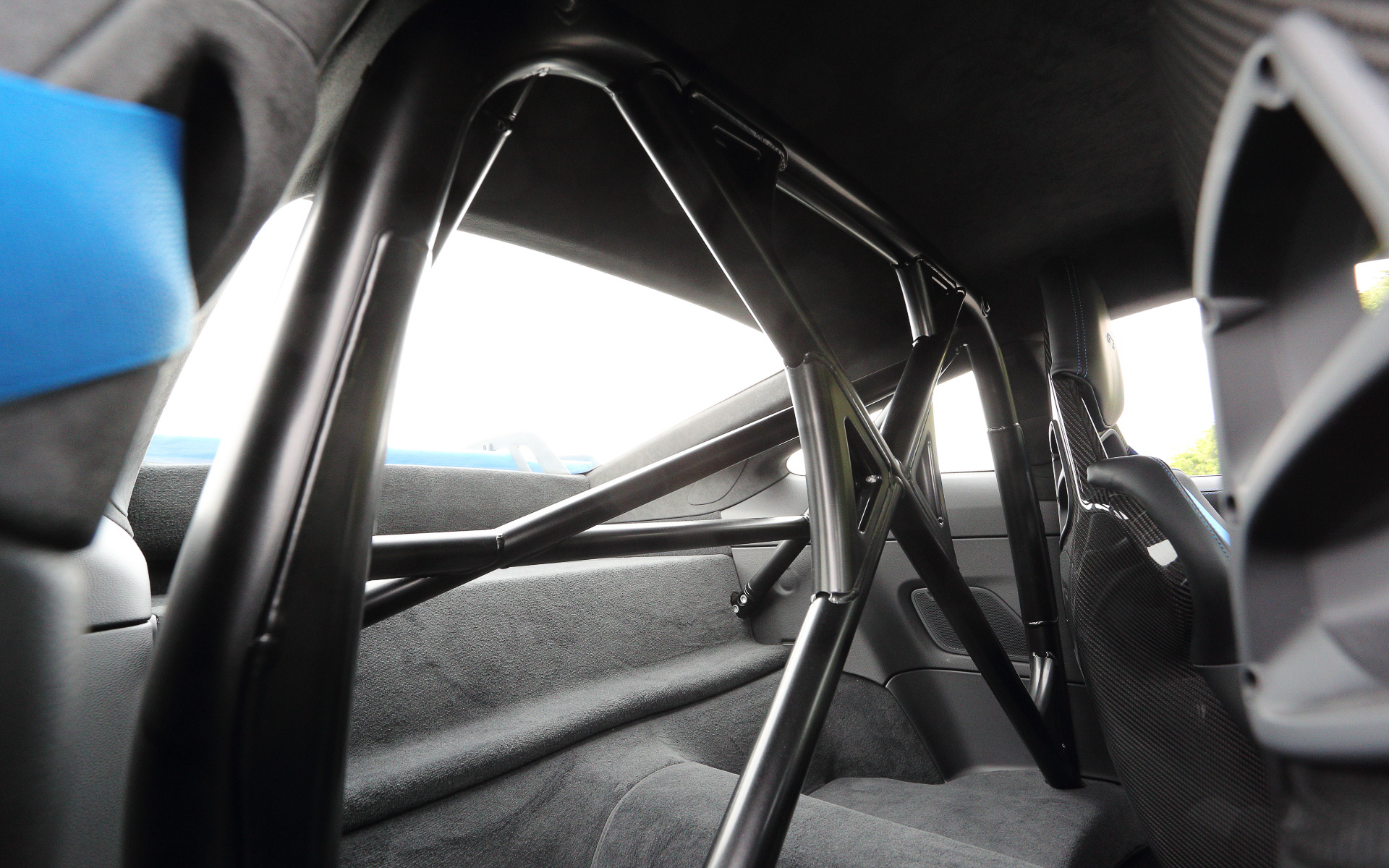 無償オプションの「クラブ スポーツ パッケージ」に含まれるスチール製ロールケージを装備して2名乗車仕様となる911 GT3のインテリア。メーター中央に最高回転数10000rpmのタコメーターをレイアウトし、タイヤ空気圧インジケーター、油圧、油温、燃料残量、水温といったサーキット走行に不可欠な情報を得ることが可能。フルバケットシートやシャークブルーカラーのシートベルトなどはオプション設定