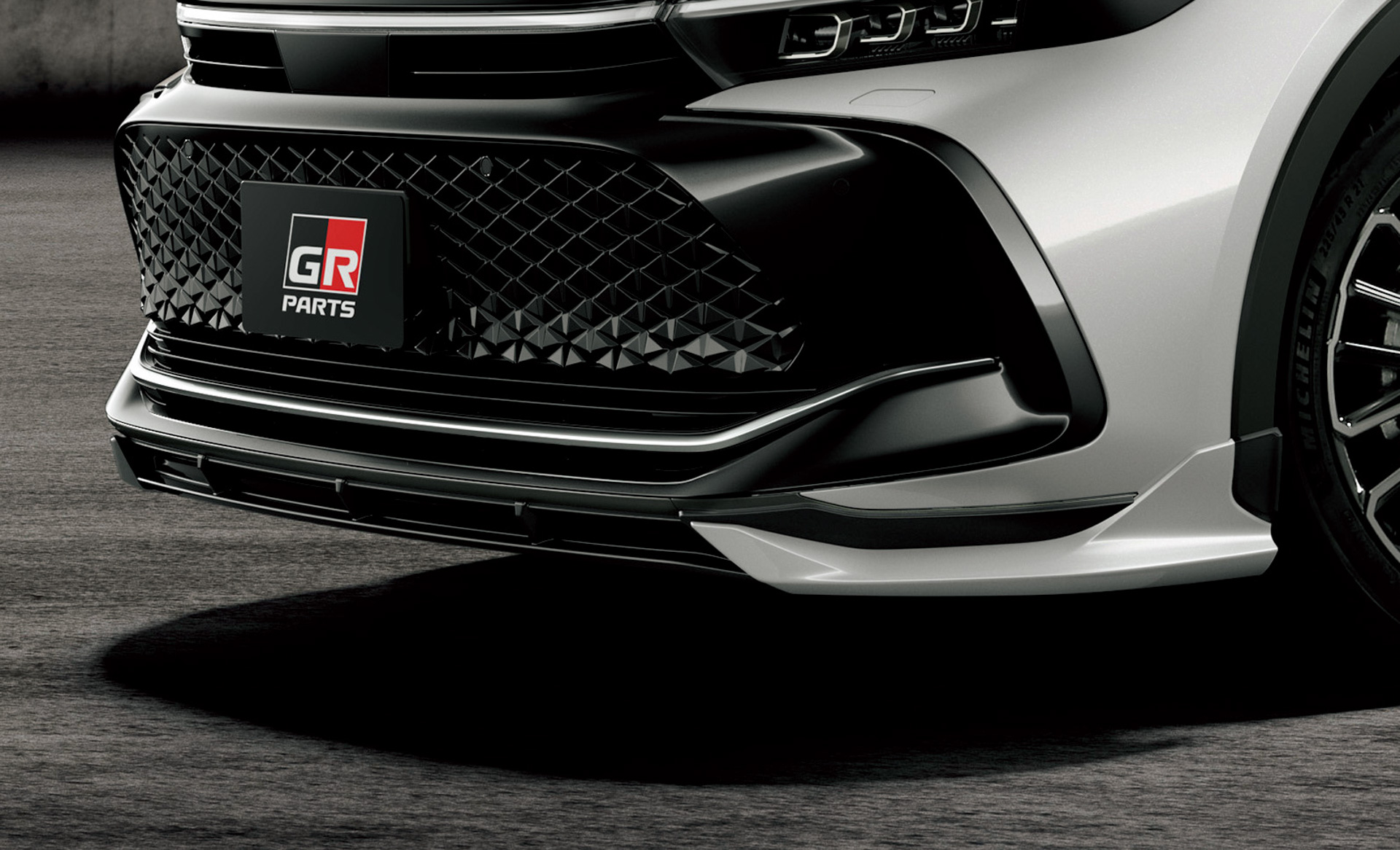 GRフロントスポイラー：サイドピースをフィン形状としダウンフォースを生み出す造形を採用し、ボディ同色とする事でワイド感のあるフロントフェイスを創出。センターピースはベース車のブラックアウトされたボンネットフード（2トーン仕様の場合）とシンクロさせ、ブラックで構成しており、3本の縦フィンがアイキャッチとなり低重心感を強調させた
