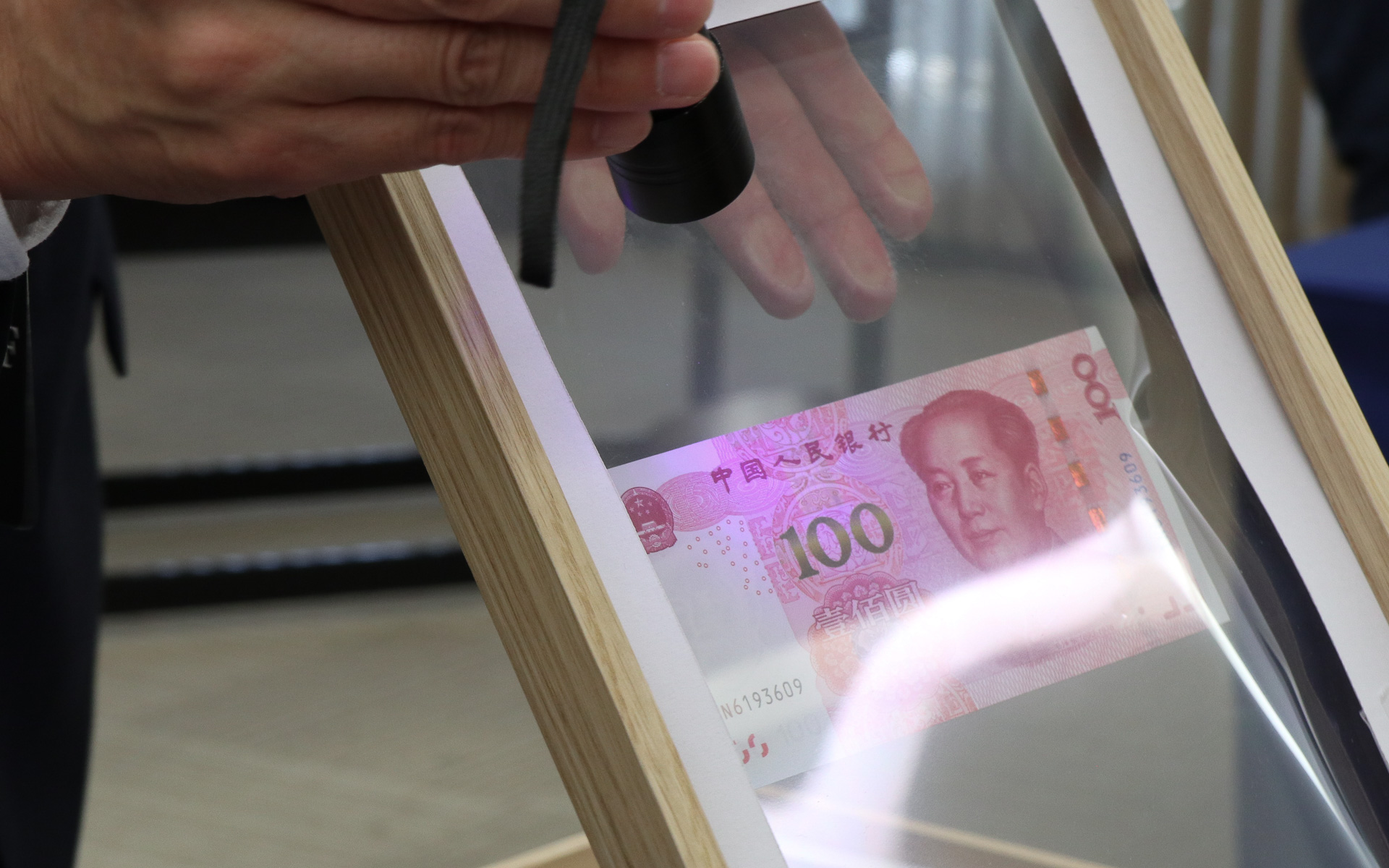 他社製品とahead製品のウィンドウフィルムをそれぞれ木製フレームに入れて被せた上からブラックライトを照射