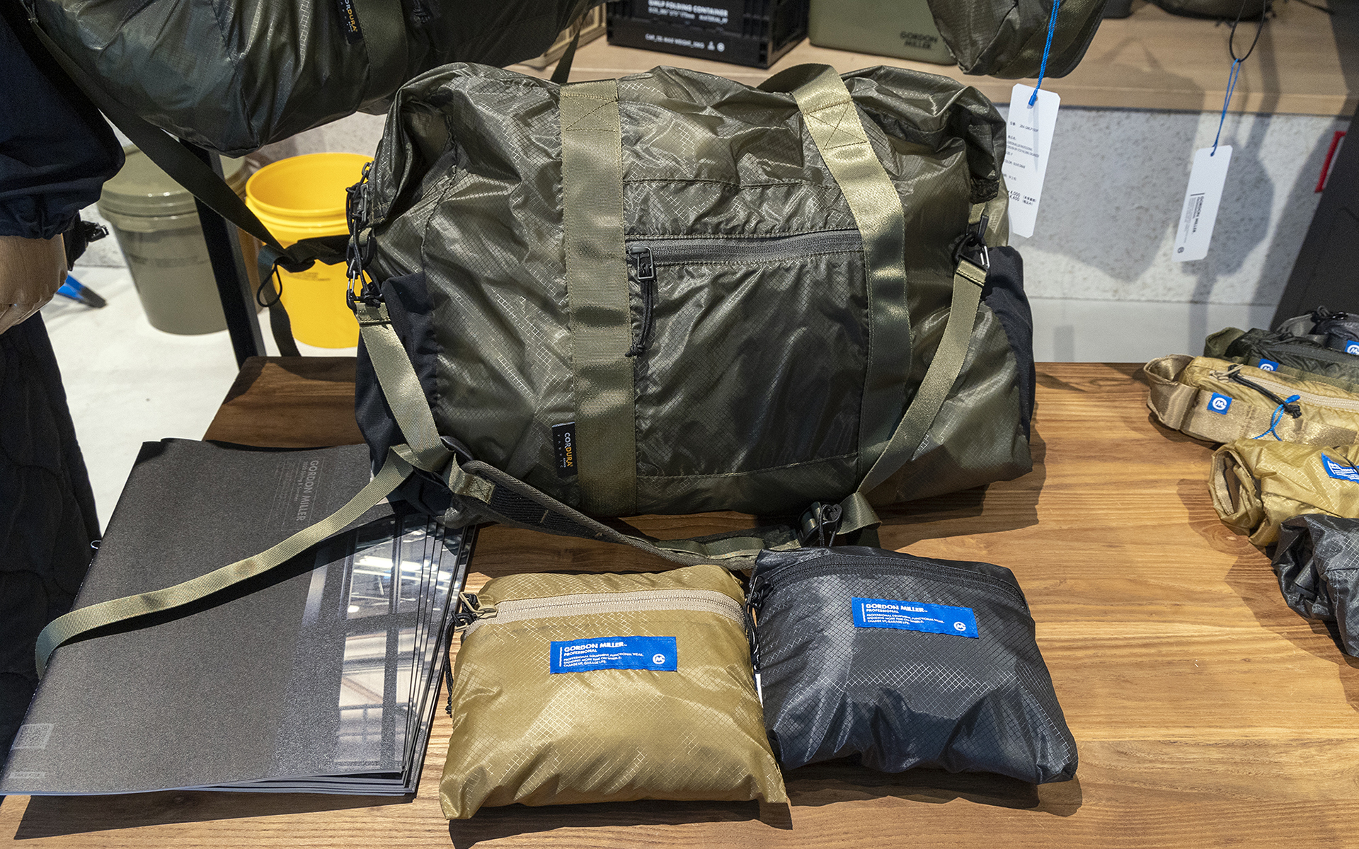 コンパクトにたためるバッグ。サイズは大小各種用意。写真のボストンバッグ、手前はたたんだ状態。車中泊時に温泉などに立ち寄るときにちょうどいいサイズ。バスタオルを入れても余裕