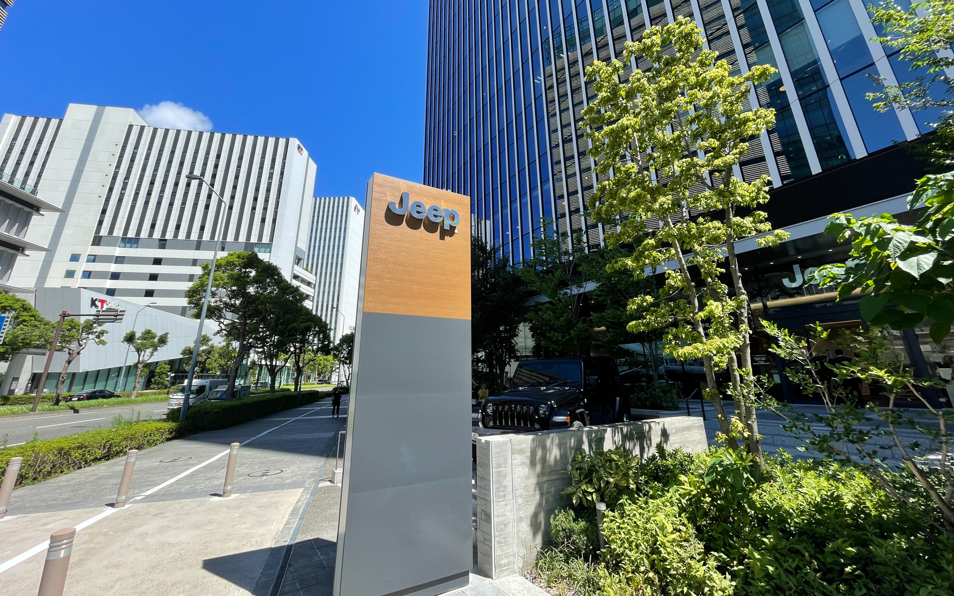 複合施設の1階にあるショールームは、道路面より数段上がった位置にあり、ジープの新CIであるブラックとウッドパネルを外観にまとった趣のあるデザインを採用。内照式ジープロゴのブランドバッチサインとディーラーネームサインを正面に配し、また敷地内のパイロンサインにより道路からの視認性を高めた