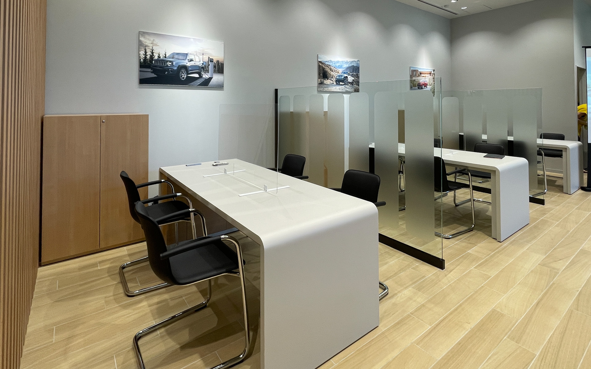 商談ブーススペースは対面形式でガラスパーテーションで仕切られる。壁面にジープのグラフィックを設置し、落ち着いた空間で商談を行なえるようにした。ブース内では顧客との対面の間にアクリルパーテーションを配備して安全対策もほどこした