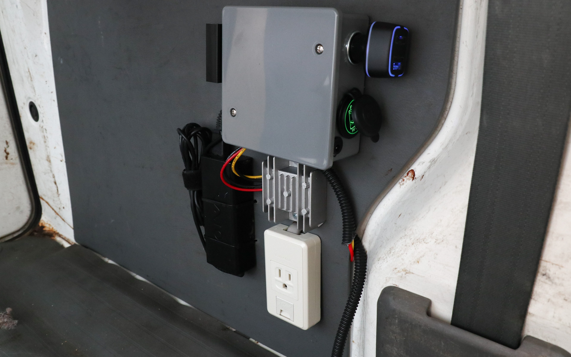 自作の車内電源システム。ありあわせ感があるのはご容赦。コンセントは外部供給をスルーするだけのものなので、クルマで移動中は使えない。外部コンセント入力については、きれいに作成し直したら紹介予定だ