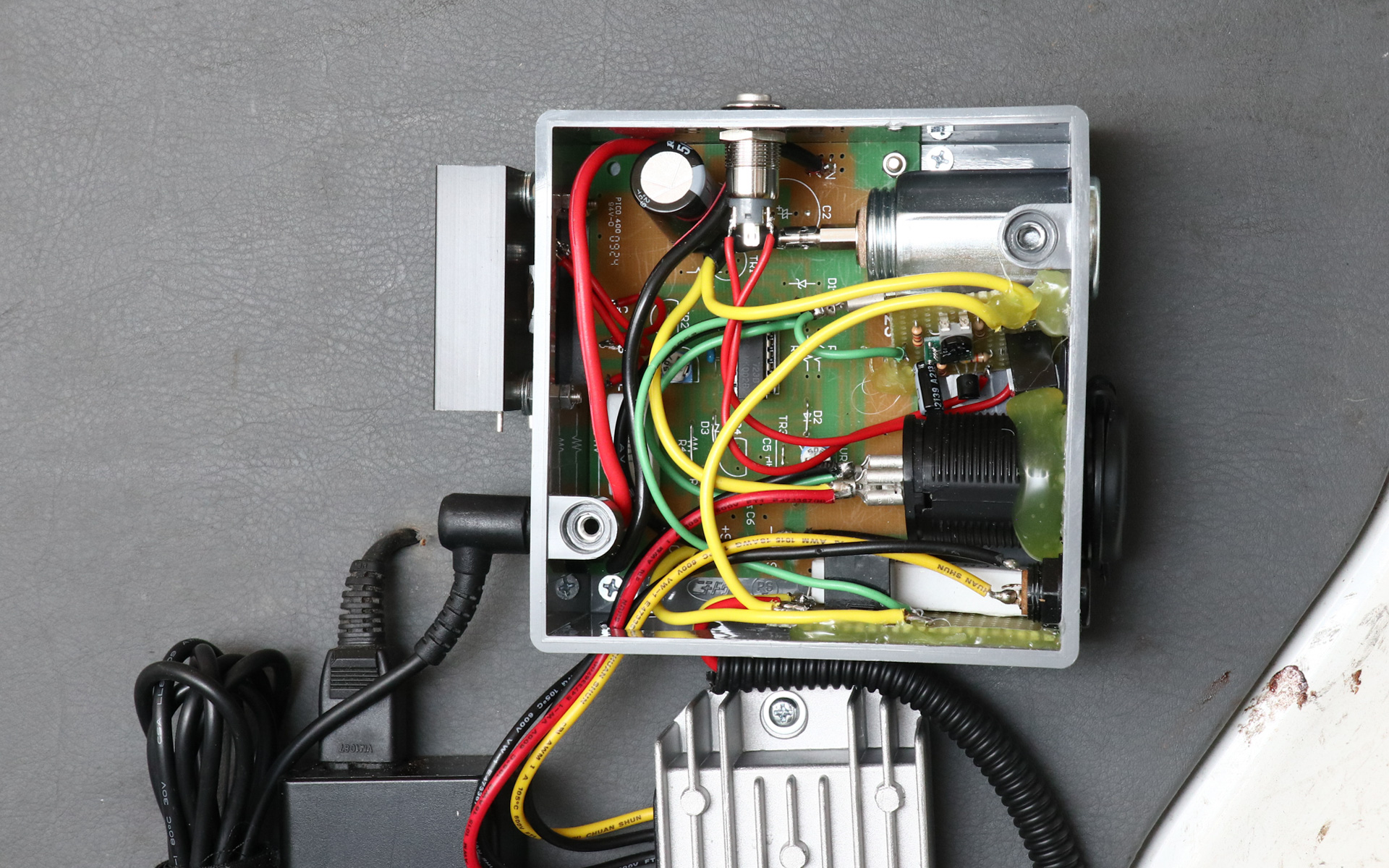 秋月電子の充電キットと過放電防止回路、充電切り替えなどを電気工事用のボックスに収納した。試作感がありありだが許されたい。USB電源ポートに変換する黒いユニットは、固定ナットを紛失したものが手持ちであったのでホットボンドで固定して使っている。ボックスの下にあるのは手持ちにあった12V固定出力のあるDC-DCコンバーターで、安定した12Vが必要な機器に電源を供給するため