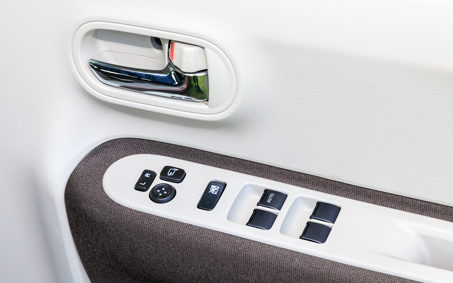 アームレストにはパワーウィンドウなどのスイッチが並ぶ。ドアハンドルはXグレードがメッキ、Lグレードはアイボリーになる