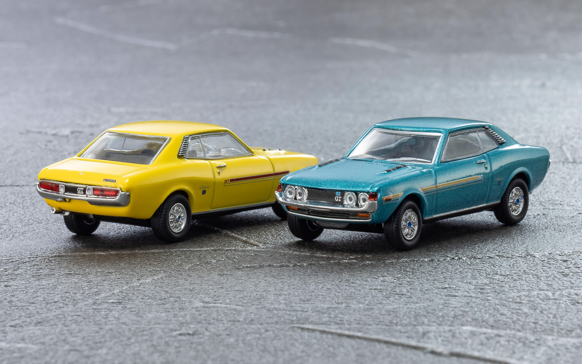 日本初の本格スペシャリティカーとして1970年12月に登場したセリカ（TA22型）。当時としては珍しい丸みを帯びたフォルムから「だるま」の愛称で親しまれ、エンジン、ミッション、外観、内装を自由に組み合わせることが可能なフルチョイスシステムが話題となった1台。スポーツグレードの1600GTは、モータースポーツで好成績を収めている。カラーはイエローとブルー