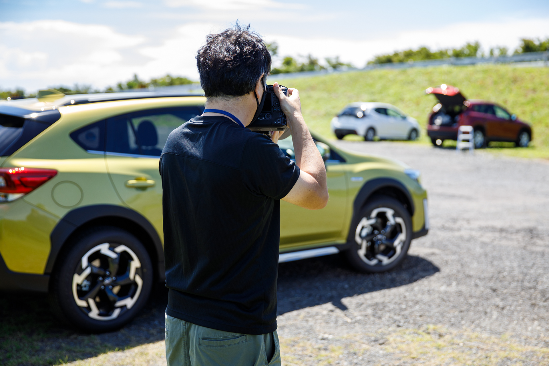 タイヤまわりの撮影風景。写真に写ってはいないが、向かって右側からレフ板で補助光を当てている。この補助光によってホイールに輝きが出て、タイヤ側面も暗くなりすぎずにすんでいる。さらに車体の下にワイヤレスのフラッシュを配置し、タイヤが路面に接する部分も照らしている