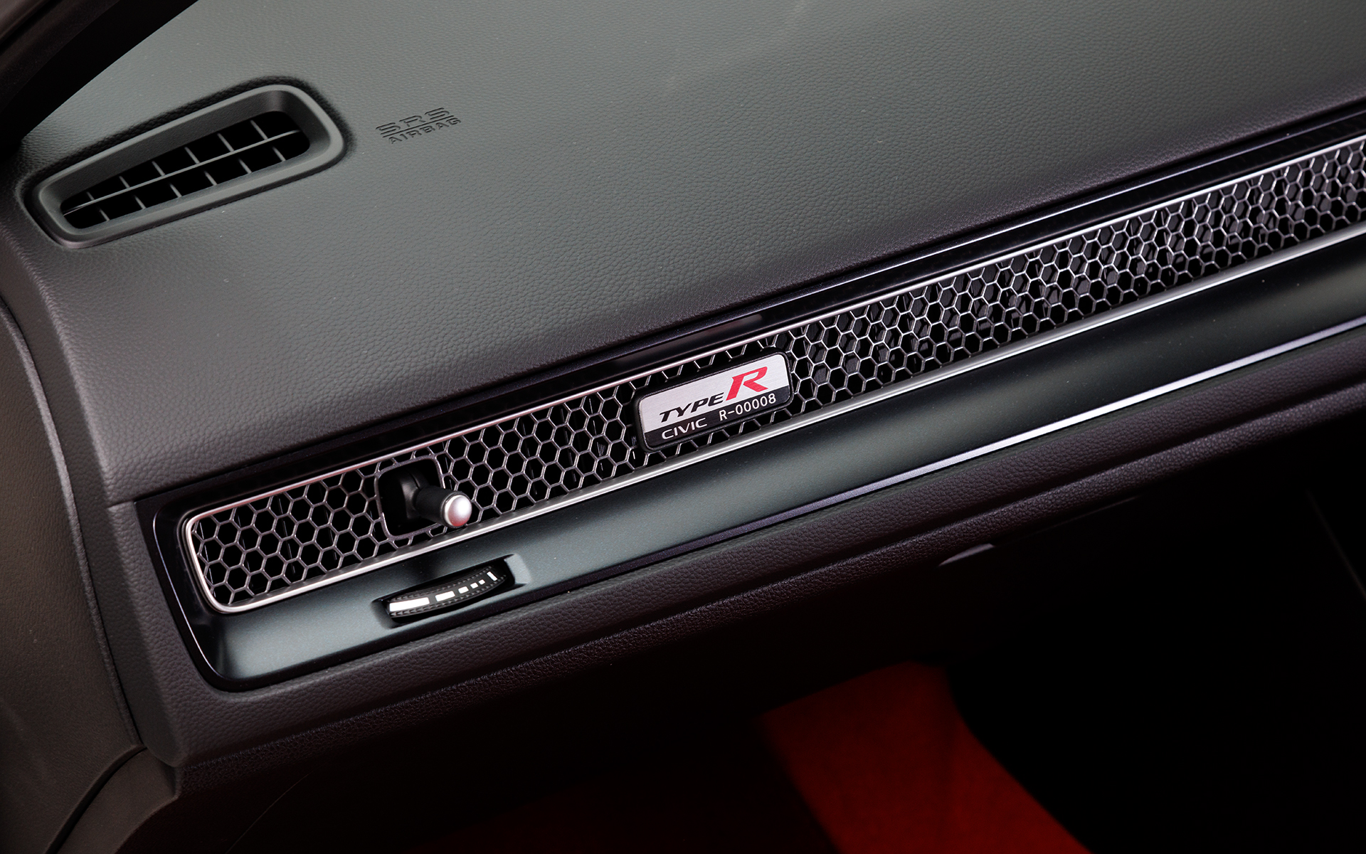 助手席前にはアルミ製のバッジ。全世界共通で5桁のナンバーが入る