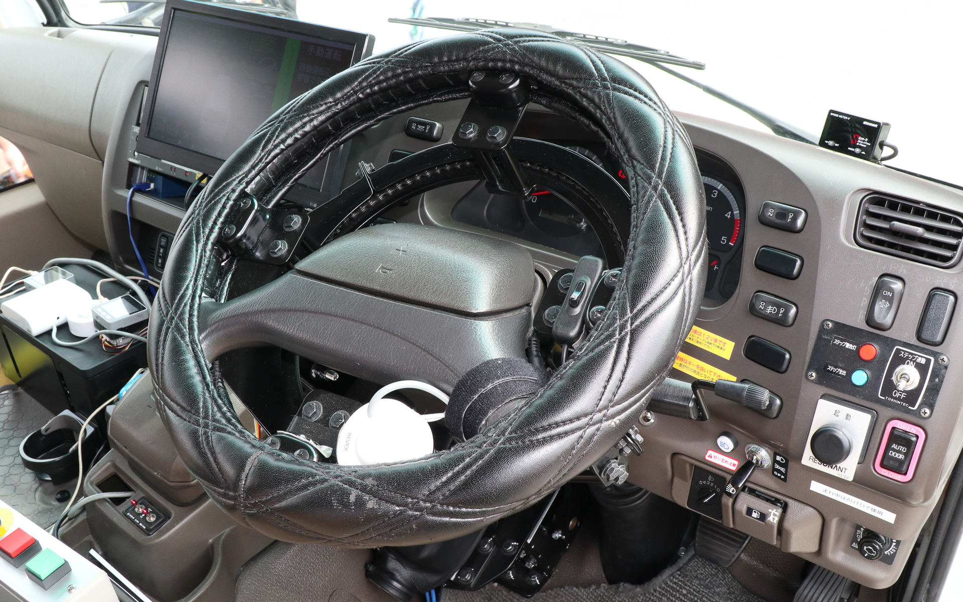 ステアリングの奥に追加されたリング状の「ハンドル連携装置」でステアリングを操作