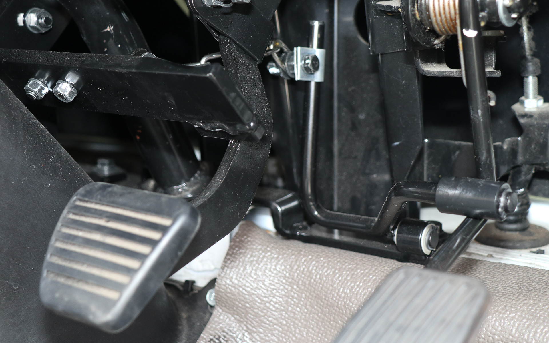 アクセルとブレーキのペダル奥側に連携装置のアームを追加して、運転手もそのまま運転操作ができるようにしている