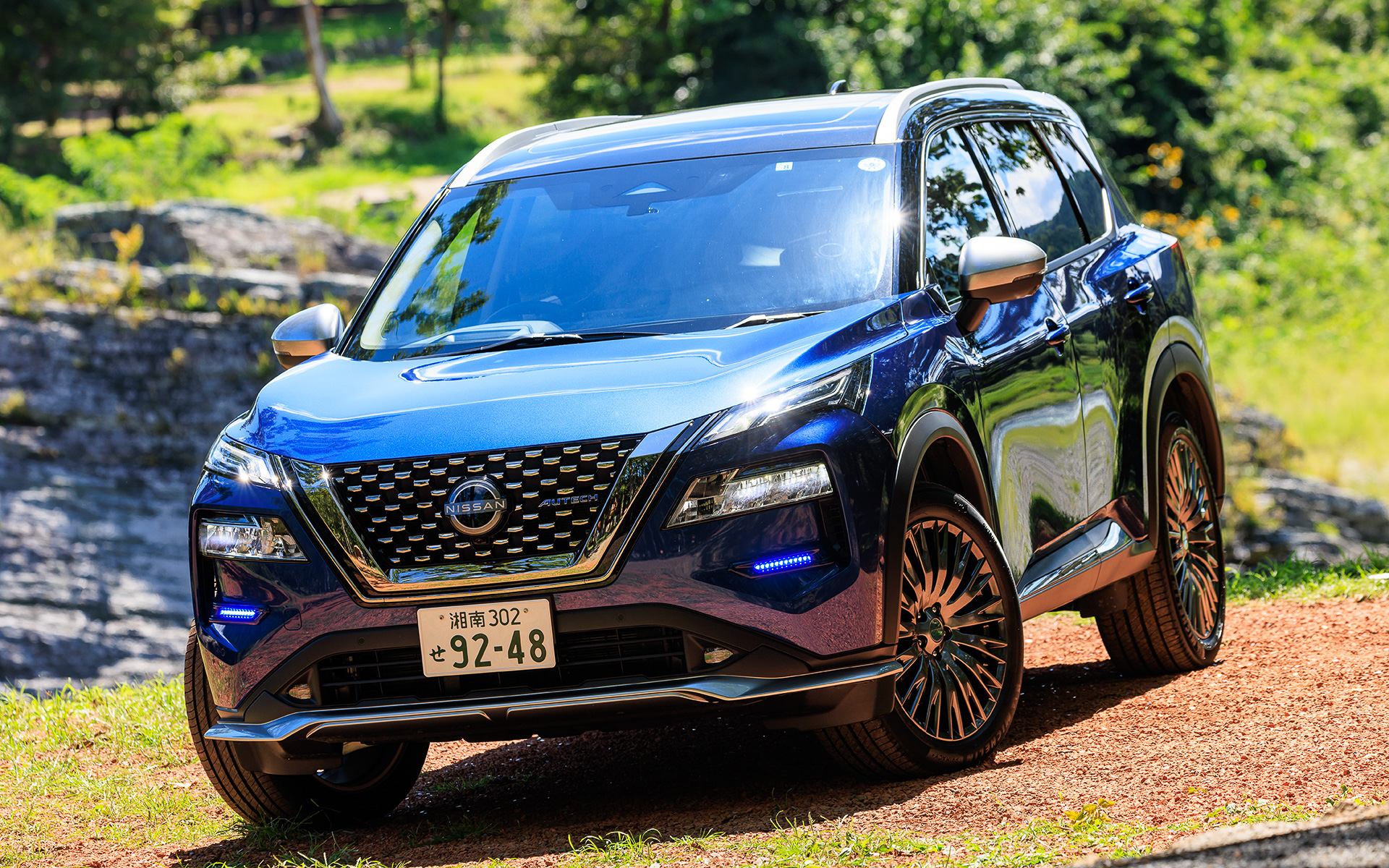 エクストレイル「AUTECH」ではドットパターンのフロントグリルやブルーに輝くシグネチャーLEDを採用するとともに、メタル調フィニッシュの専用パーツを車体下部に装備。また、エクストレイルで唯一20インチアルミホイール（タイヤはミシュラン「プライマシー4」）をセットする。価格は420万5300円～504万6800円