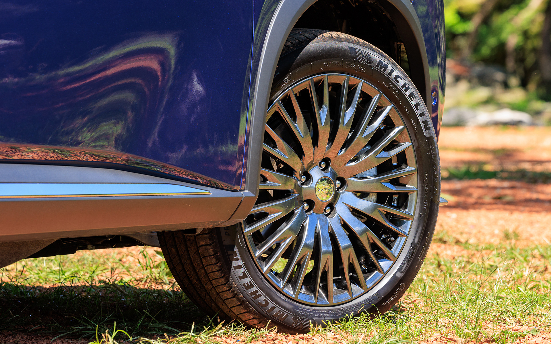 エクストレイル「AUTECH」ではドットパターンのフロントグリルやブルーに輝くシグネチャーLEDを採用するとともに、メタル調フィニッシュの専用パーツを車体下部に装備。また、エクストレイルで唯一20インチアルミホイール（タイヤはミシュラン「プライマシー4」）をセットする。価格は420万5300円～504万6800円